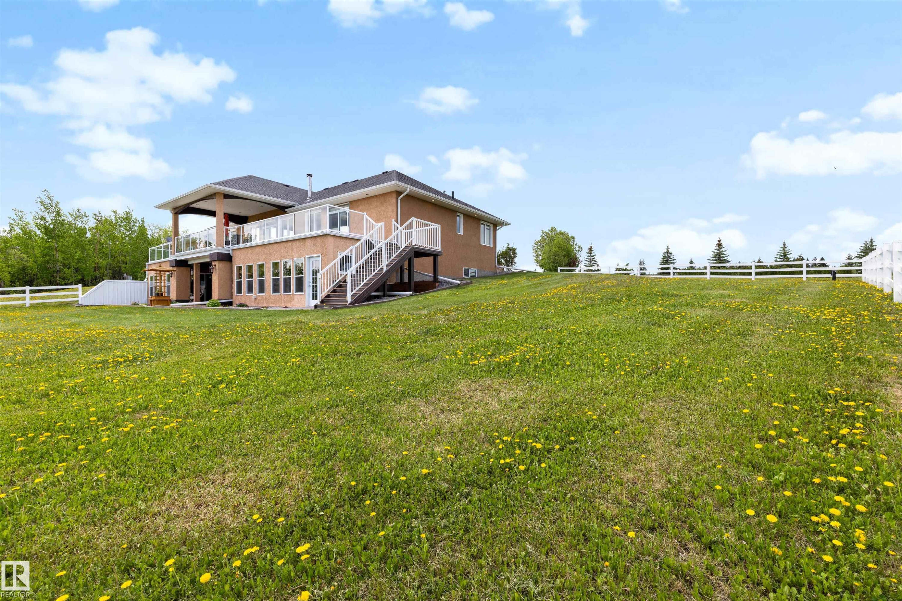 Expansive grassy yard with a white fence bordering the property - 28125 Highway 587, Rural Red Deer County, AB - Outdoor With Deck Patio Veranda