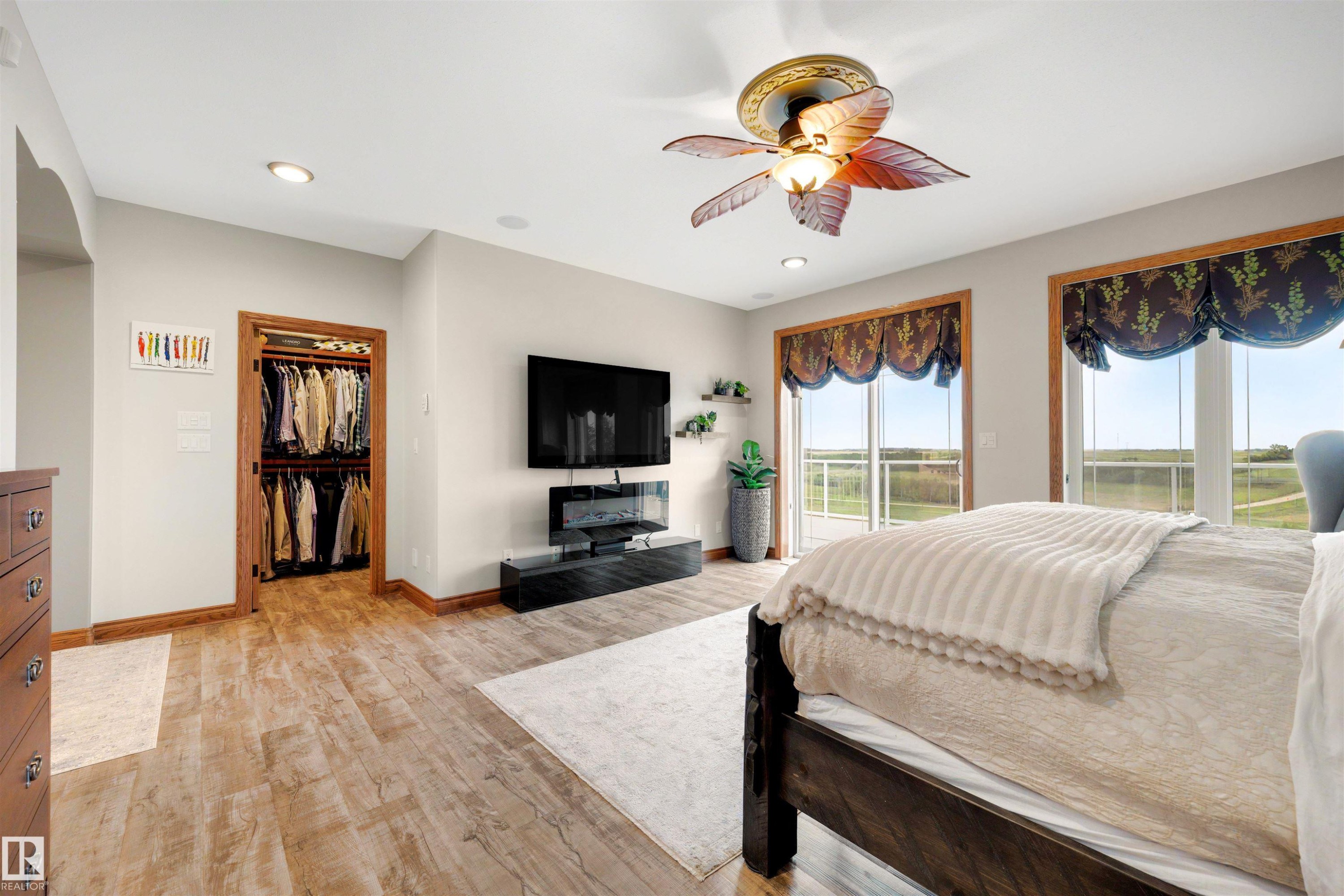 Spacious room featuring wood-finish flooring, recessed lighting, and a decorative ceiling fan - 28125 Highway 587, Rural Red Deer County, AB - Indoor Photo Showing Bedroom