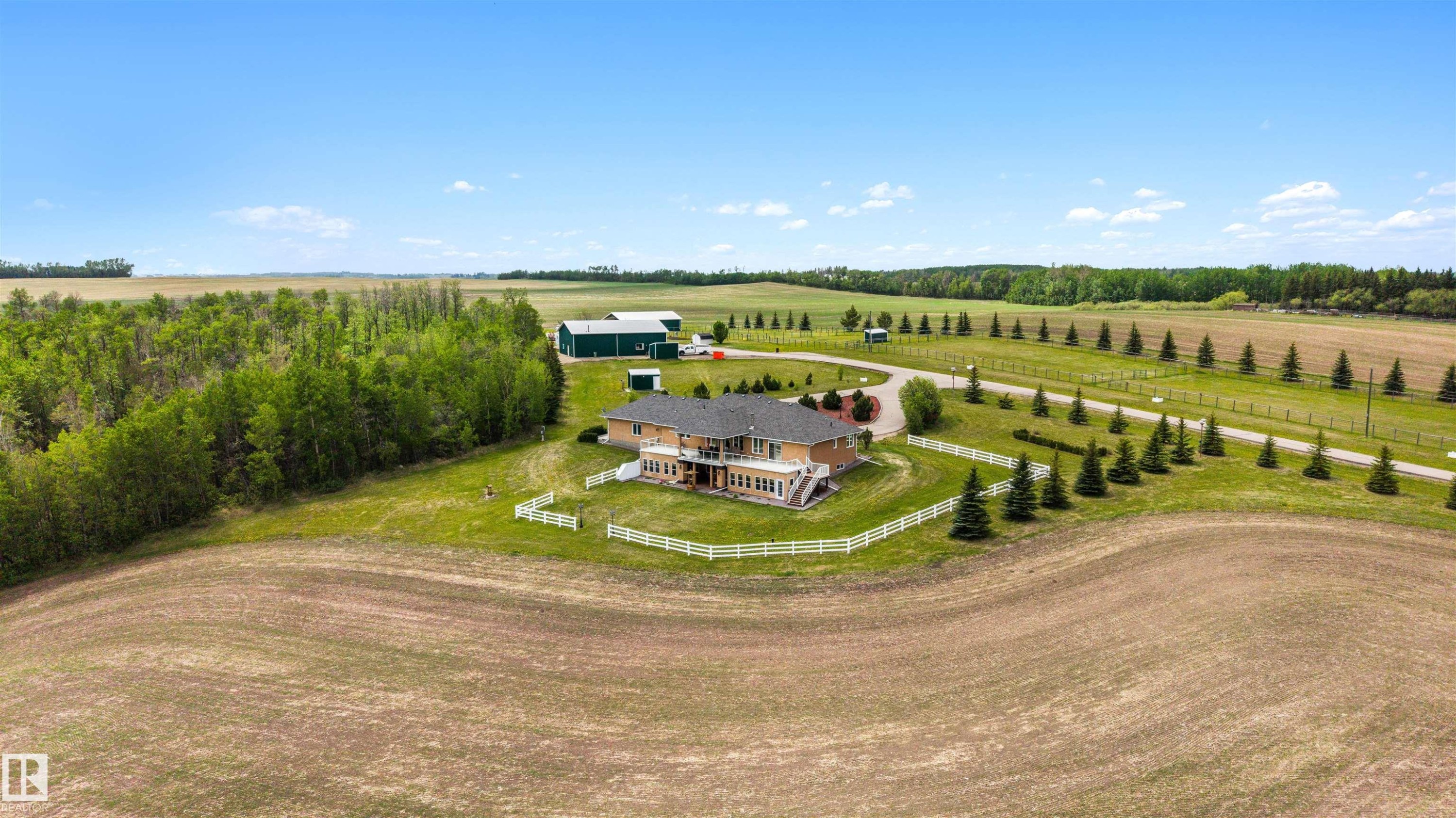 Expansive rural property featuring a two-story residence with a walk-out lower level and multiple upper-story balconies - 28125 Highway 587, Rural Red Deer County, AB - Outdoor With View