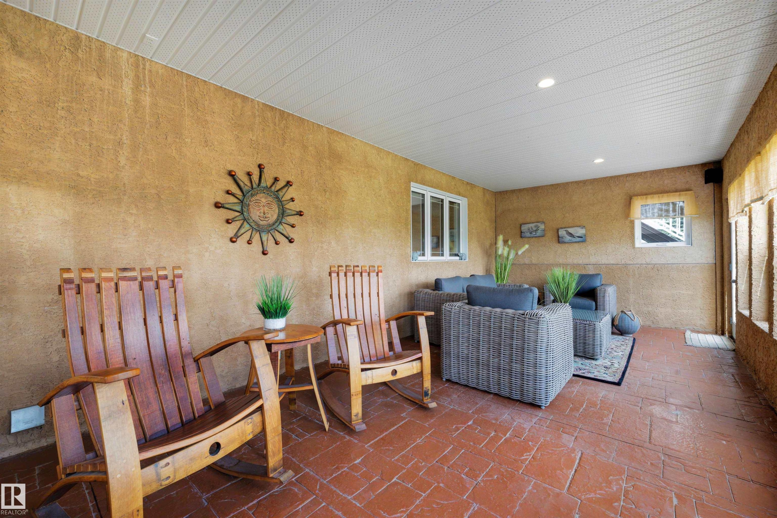 Screened porch featuring textured walls, a white slatted ceiling with recessed lighting, and stamped concrete flooring - 28125 Highway 587, Rural Red Deer County, AB - Indoor