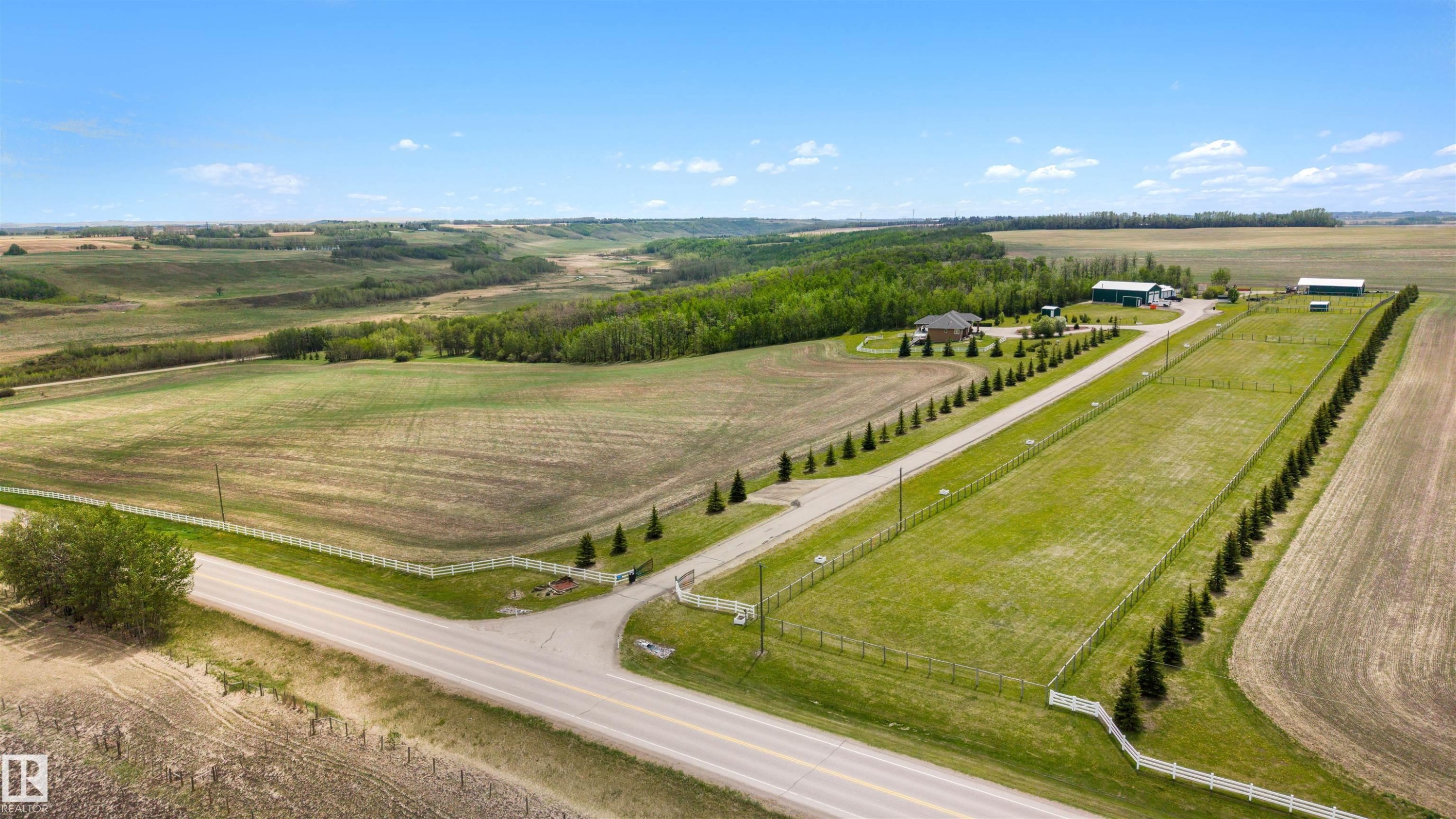 Expansive rural property featuring a main residence, multiple outbuildings, a paved driveway, and established tree lines - 28125 Highway 587, Rural Red Deer County, AB - Outdoor With View