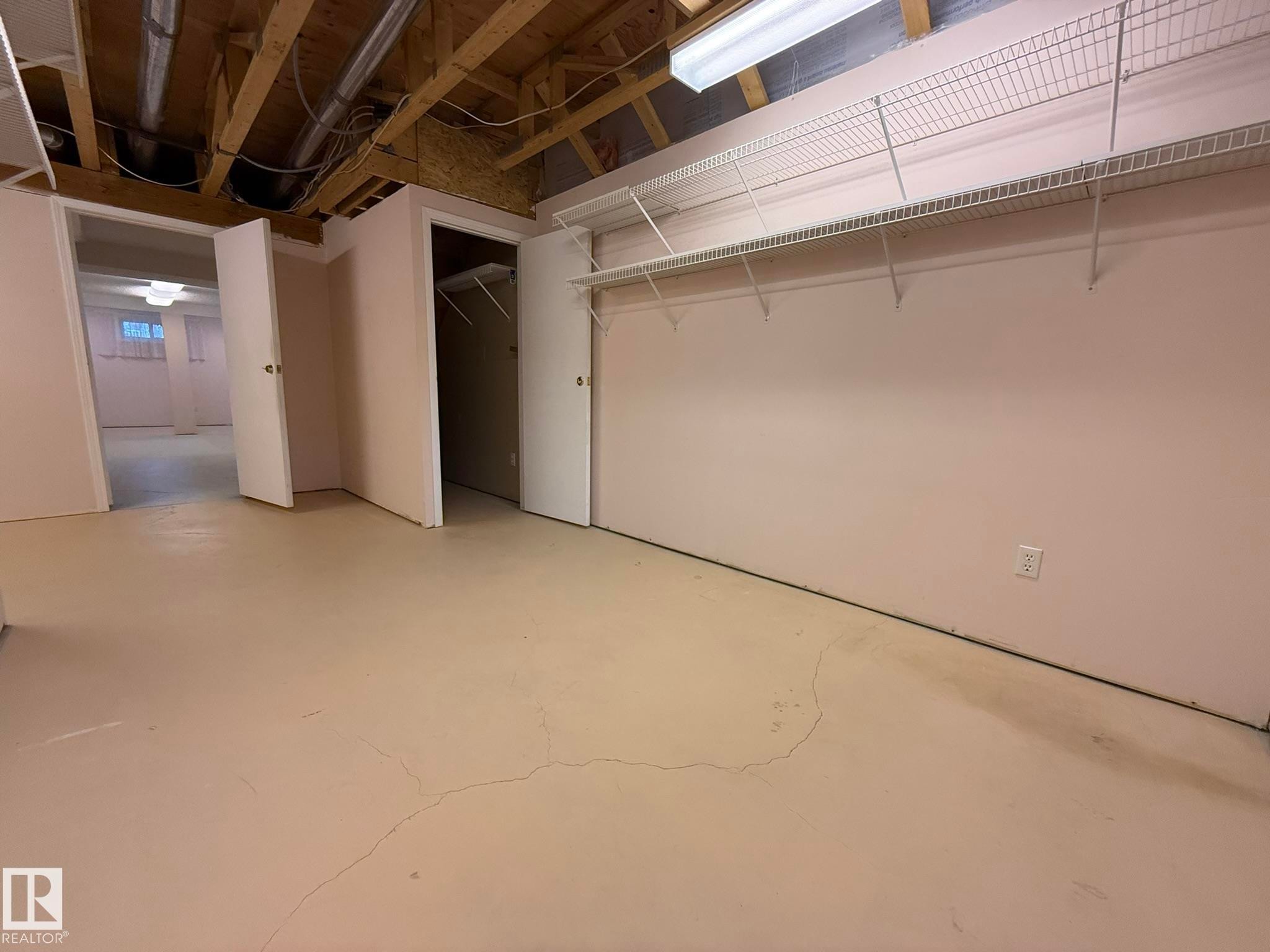 Utility space featuring exposed ceiling joists and unfinished overhead ductwork - 102 4610 50 Avenue, Stony Plain, AB