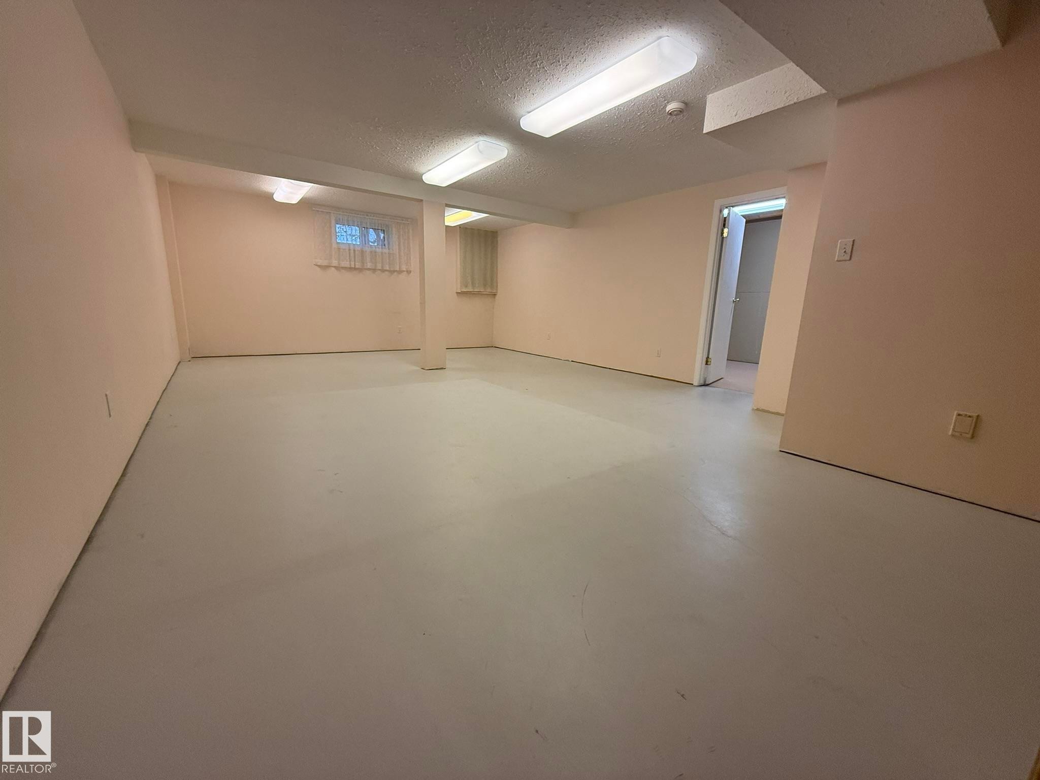Spacious room featuring light-colored walls and a light gray floor - 102 4610 50 Avenue, Stony Plain, AB
