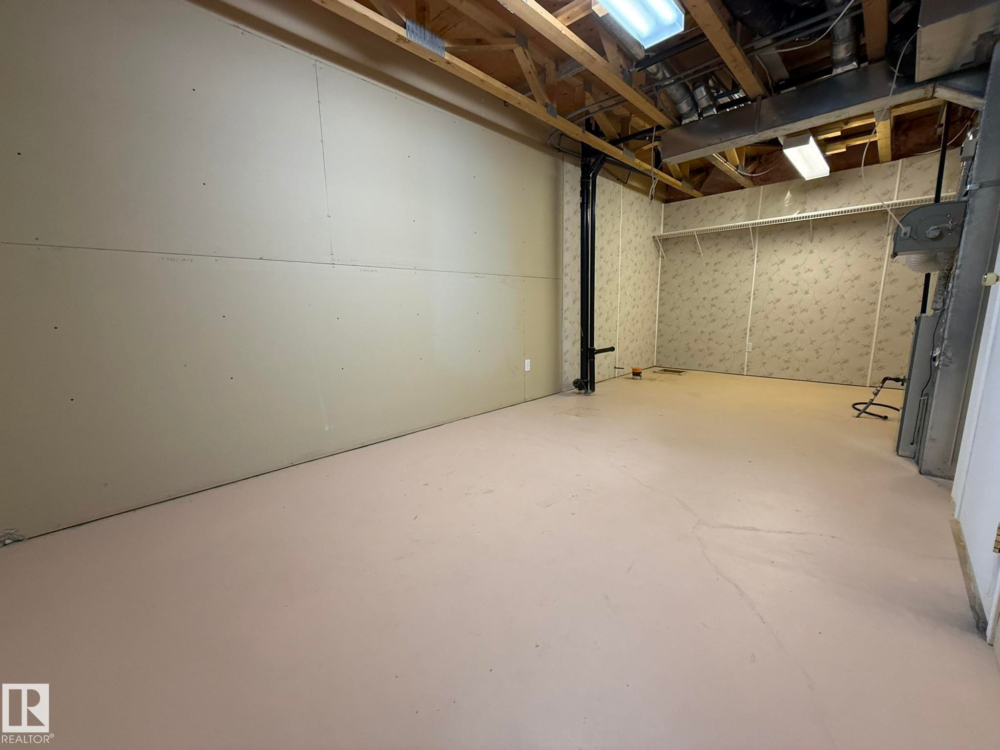Expansive unfinished basement space featuring concrete flooring - 102 4610 50 Avenue, Stony Plain, AB