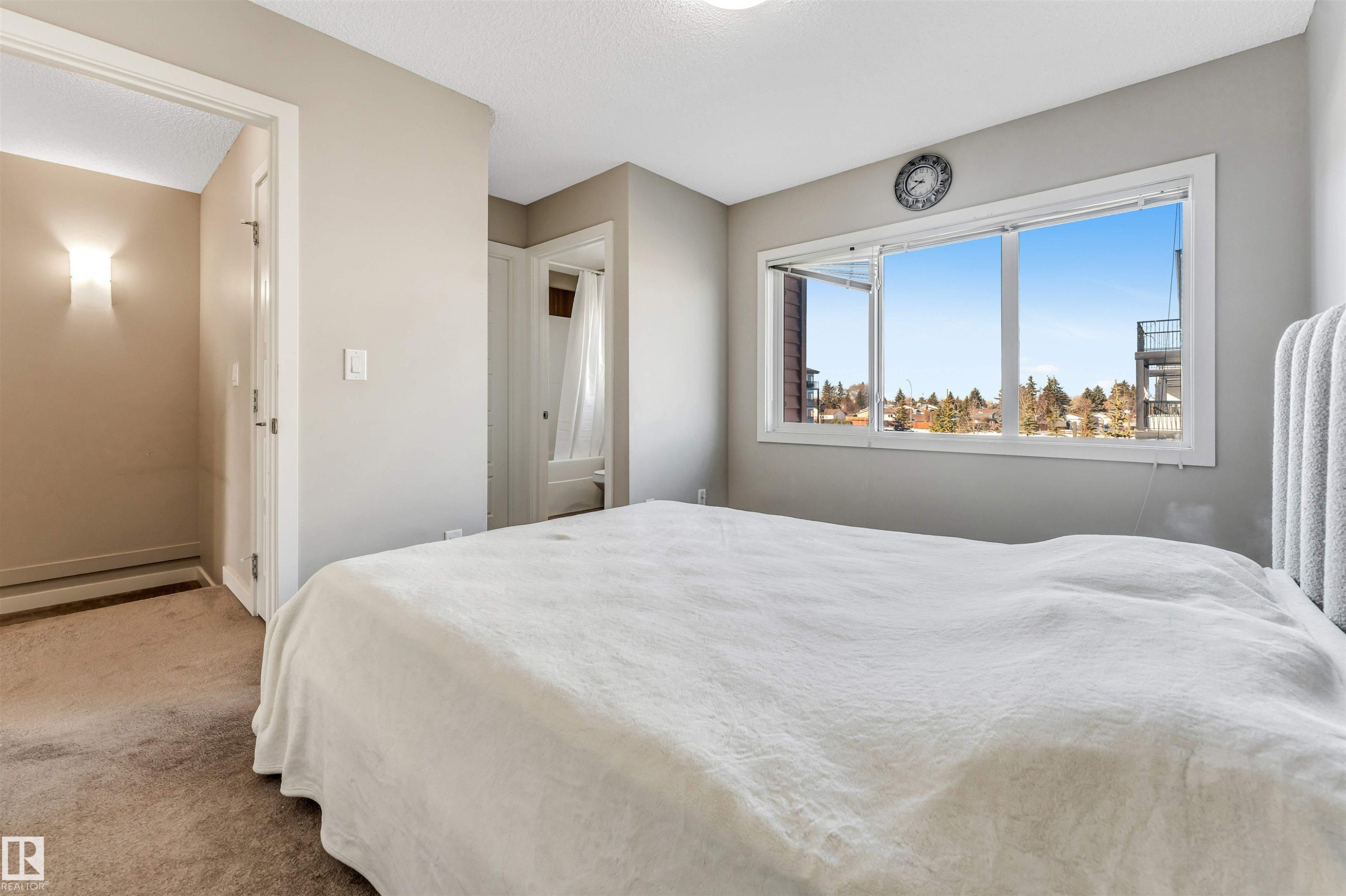 Bright room featuring a large window, neutral wall paint, and brown carpet flooring - 1624 33A Street, Edmonton, AB