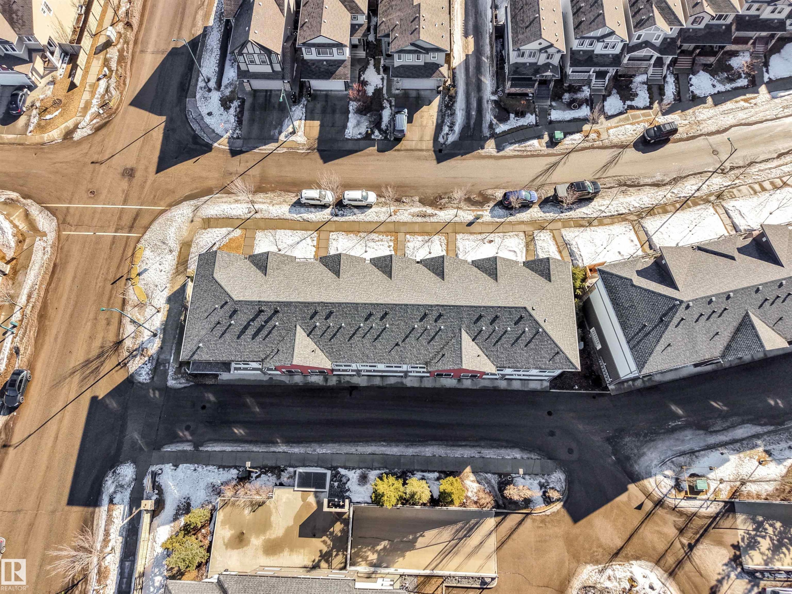 Aerial perspective showcasing a multi-unit residential building with light gray shingled roofs and dark gray siding - 1624 33A Street, Edmonton, AB