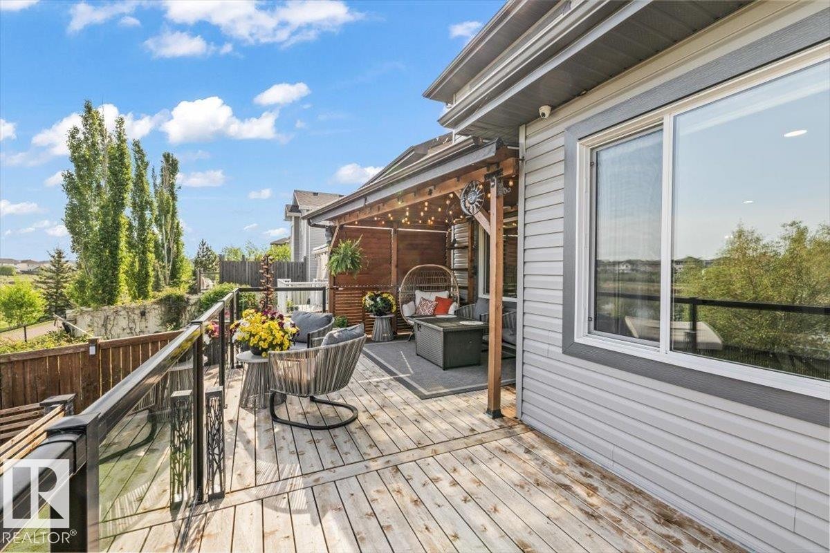 Spacious outdoor cedar deck with glass panel railing - 54 Spring Gate, Spruce Grove, AB