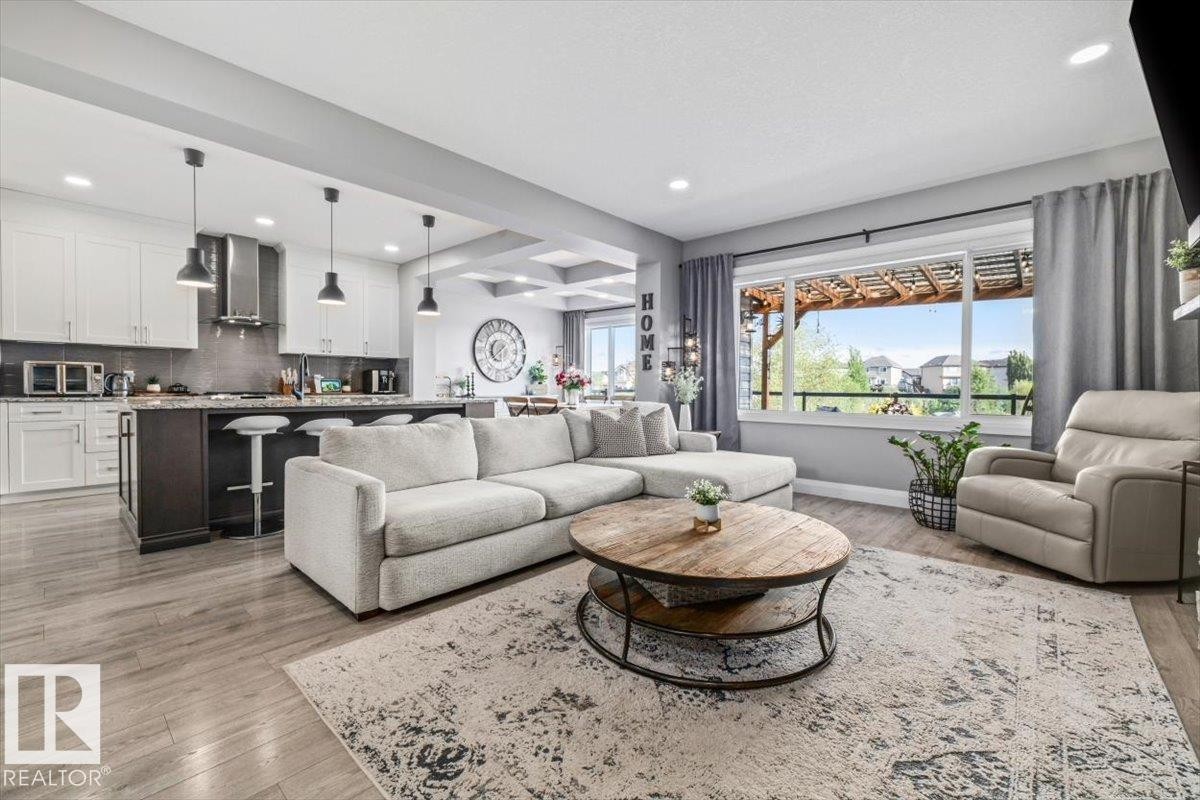Open-concept living area | Contemporary kitchen & dining | Large window overlooking a pergola - 54 Spring Gate, Spruce Grove, AB