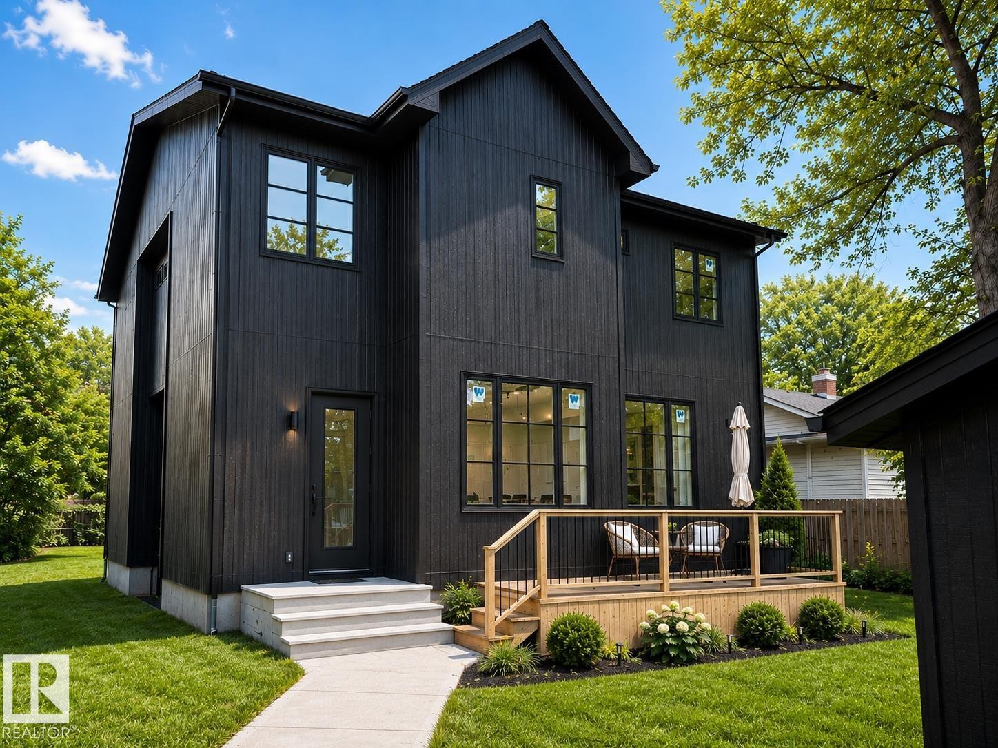 Modern two-story residence featuring black vertical siding and contrasting black-framed windows - 9243 148 Street, Edmonton, AB