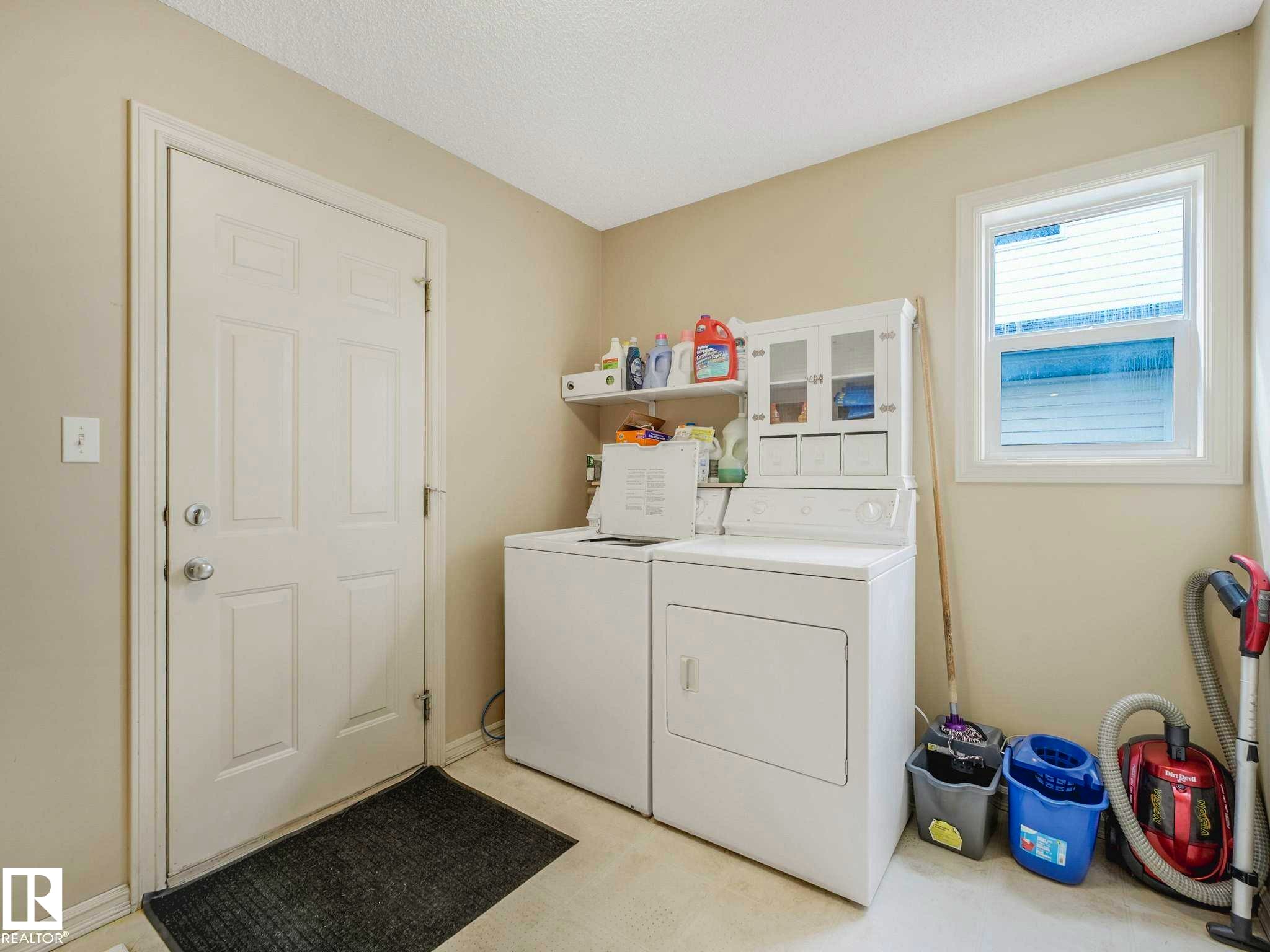 Laundry room featuring a white paneled door, a single window with white trim, and light beige wall paint - 1116 Lincoln Crescent, Edmonton, AB - Indoor Photo Showing Laundry Room
