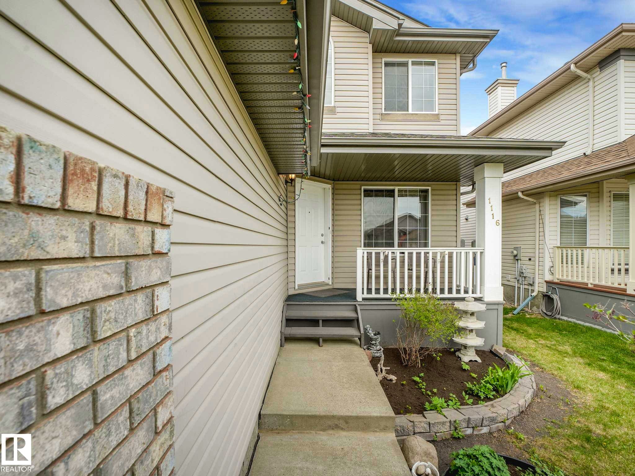 Two-story residential exterior featuring light-toned siding and brick accents - 1116 Lincoln Crescent, Edmonton, AB - Outdoor With Deck Patio Veranda