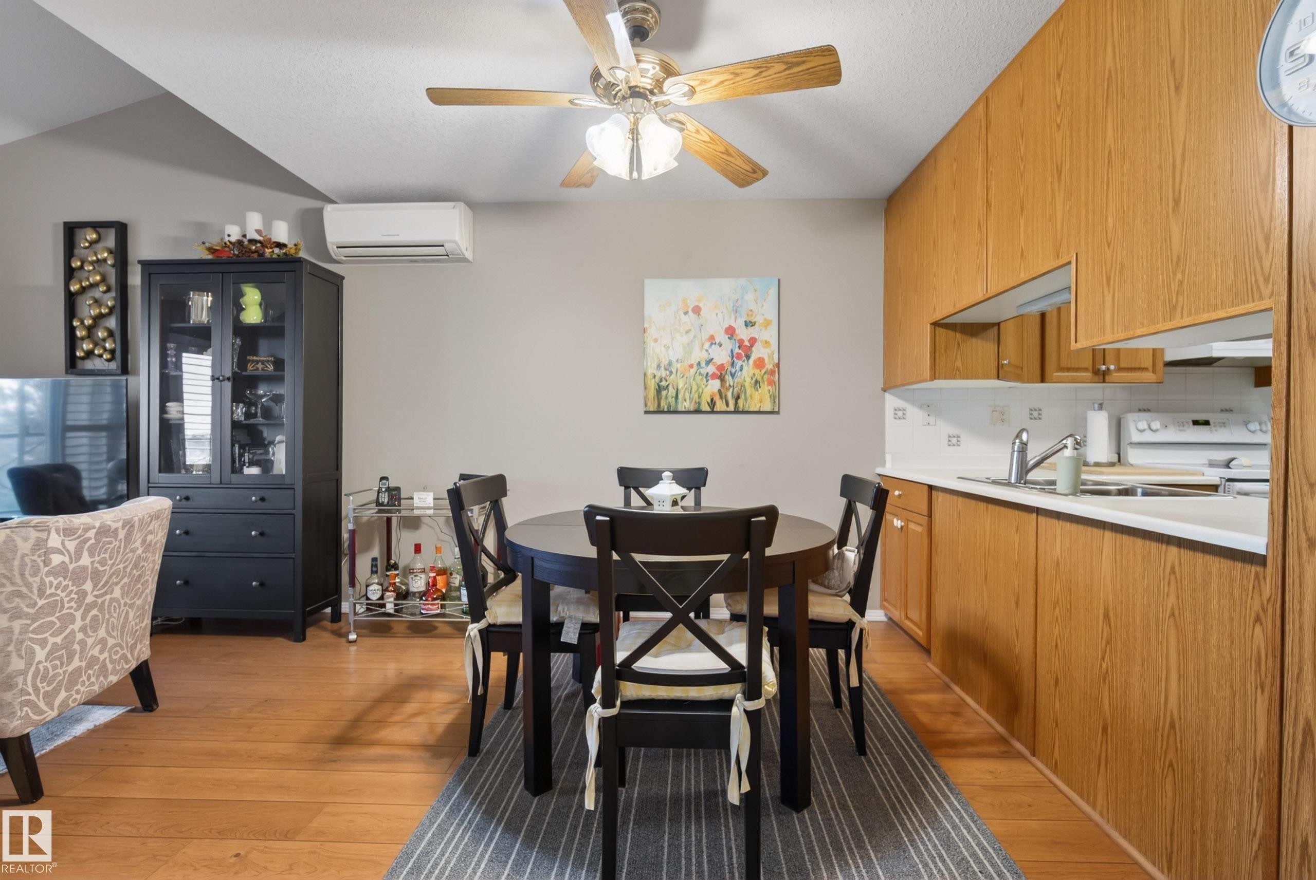 Open-concept living area with wood-finish flooring, a vaulted ceiling, and a ceiling fan - 413 8912 156 Street Nw, Edmonton, AB