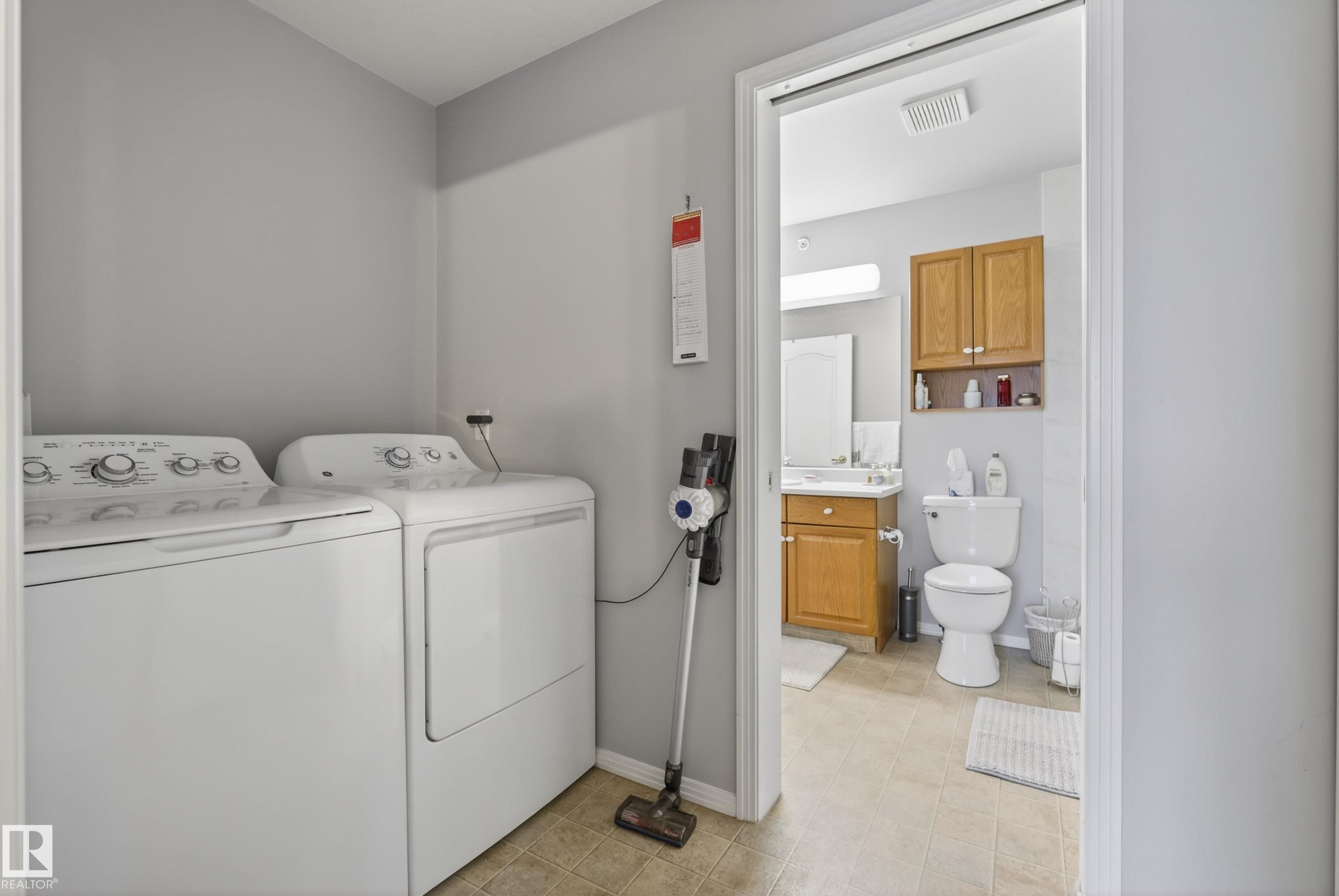 Dedicated laundry area with light gray walls and durable tile flooring - 413 8912 156 Street Nw, Edmonton, AB