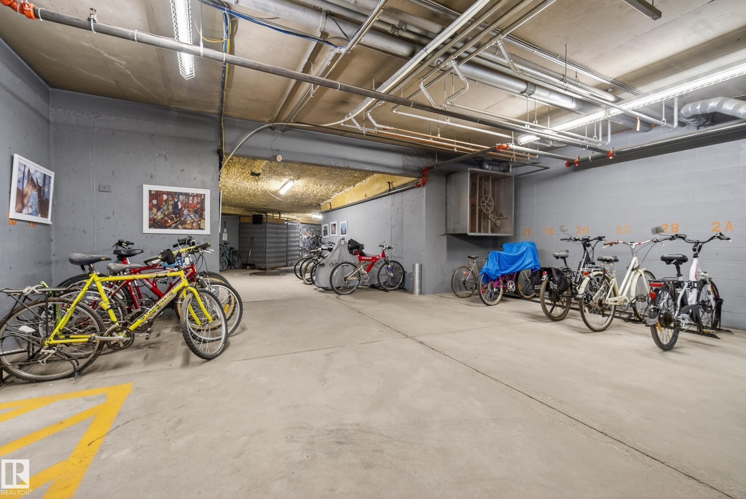 Dedicated bicycle storage area featuring concrete flooring and exposed ceiling utilities - 413 8912 156 Street Nw, Edmonton, AB