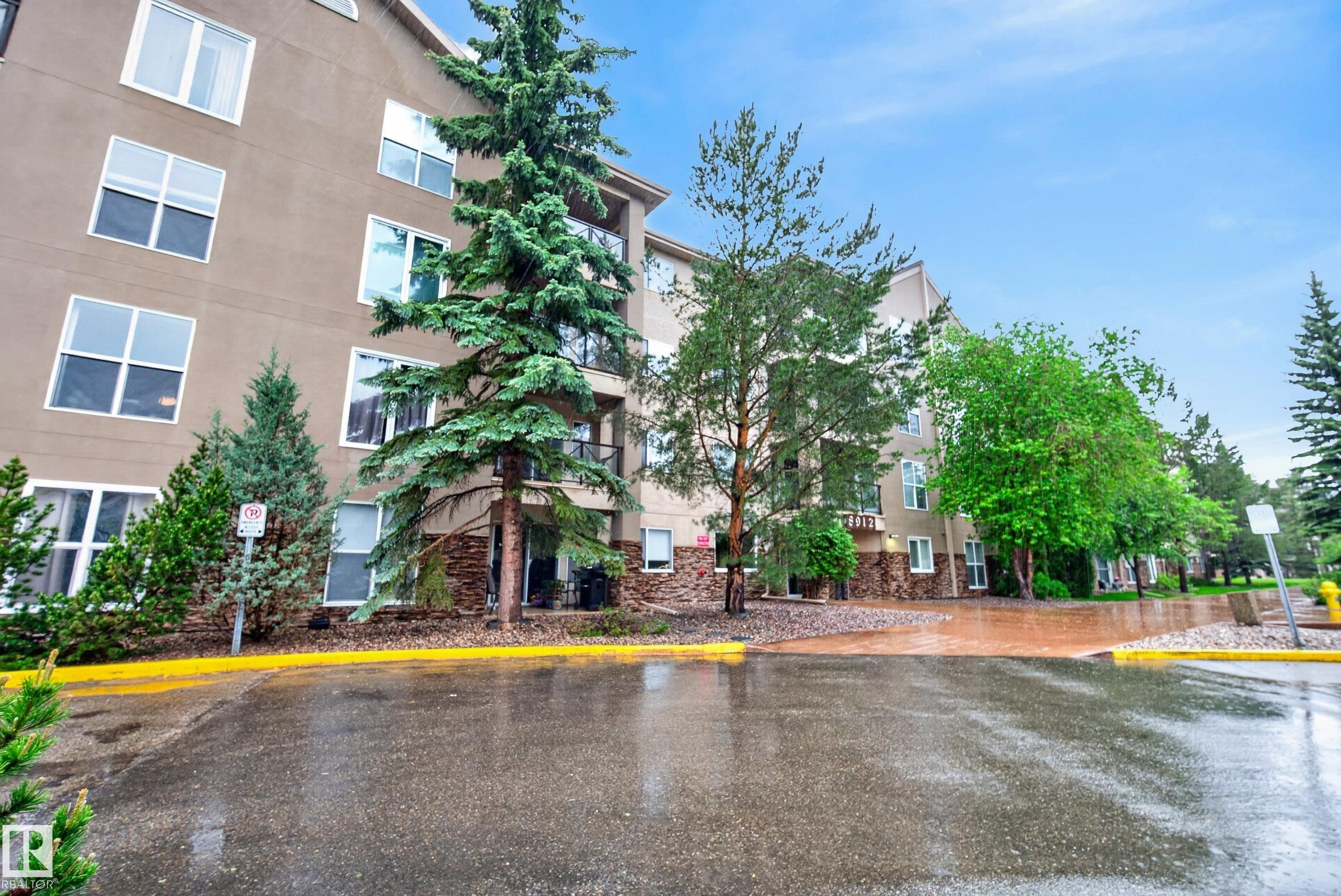 Multi-story building exterior featuring stone detailing on lower levels and multiple windows - 413 8912 156 Street Nw, Edmonton, AB