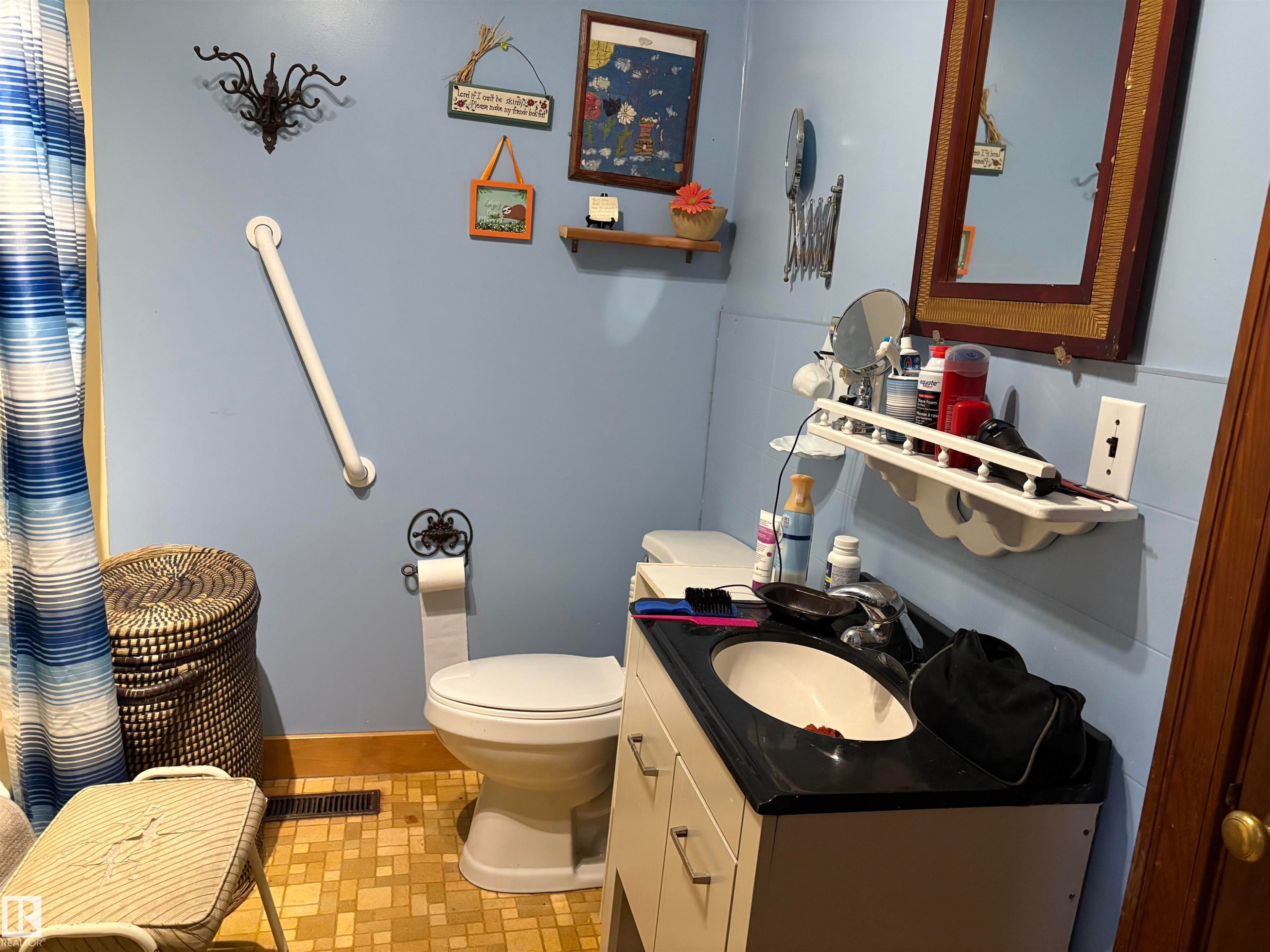 Bathroom featuring a single vanity with a black countertop, toilet. - 125 56524 Rng Rd 52A, Lindbergh, AB