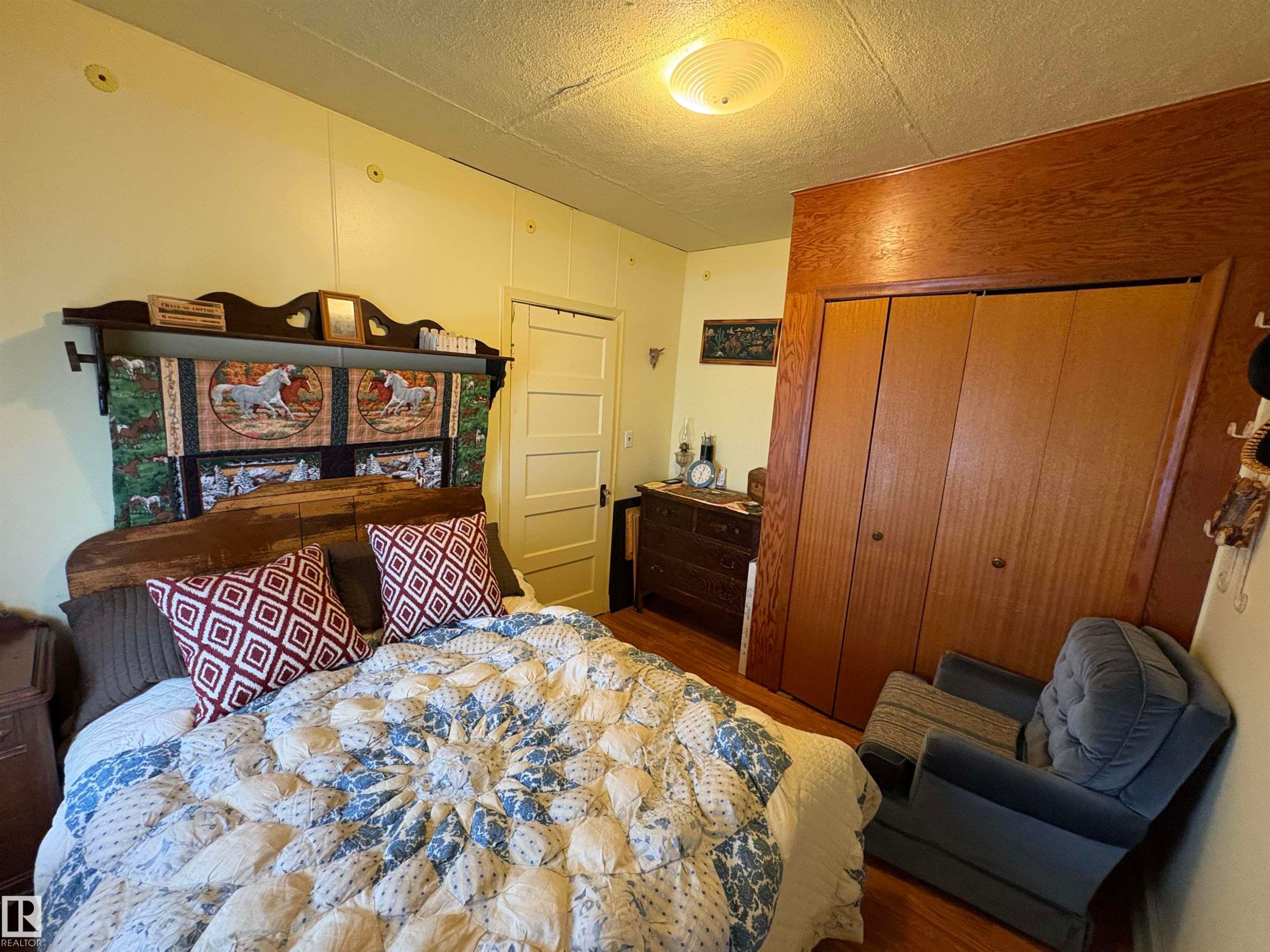 Room featuring wood-finish flooring, light-toned walls, and a ceiling-mounted light fixture. - 125 56524 Rng Rd 52A, Lindbergh, AB