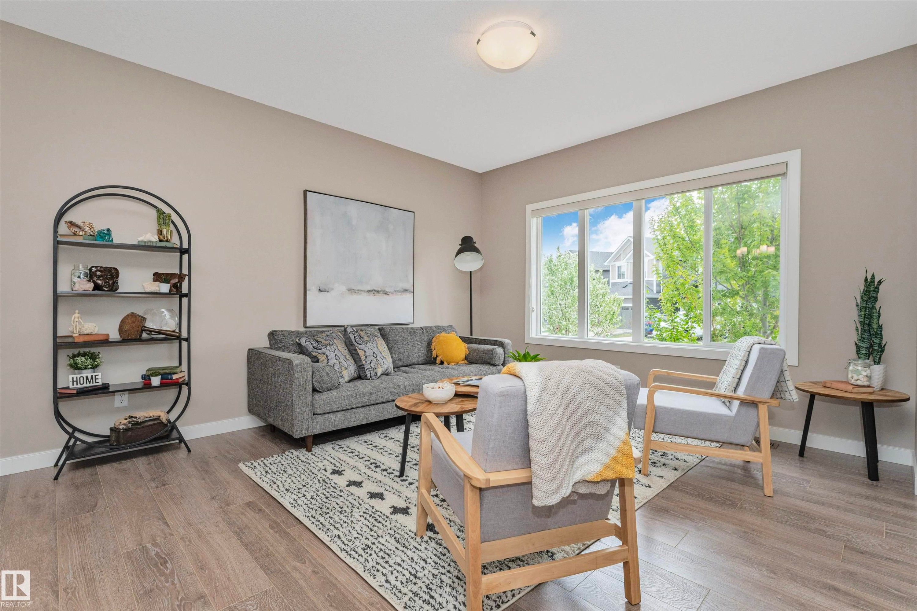 Living area featuring wood-finish flooring, a large multi-pane window, and neutral wall tones - 22124 85 Avenue Nw, Edmonton, AB - Indoor Photo Showing Living Room