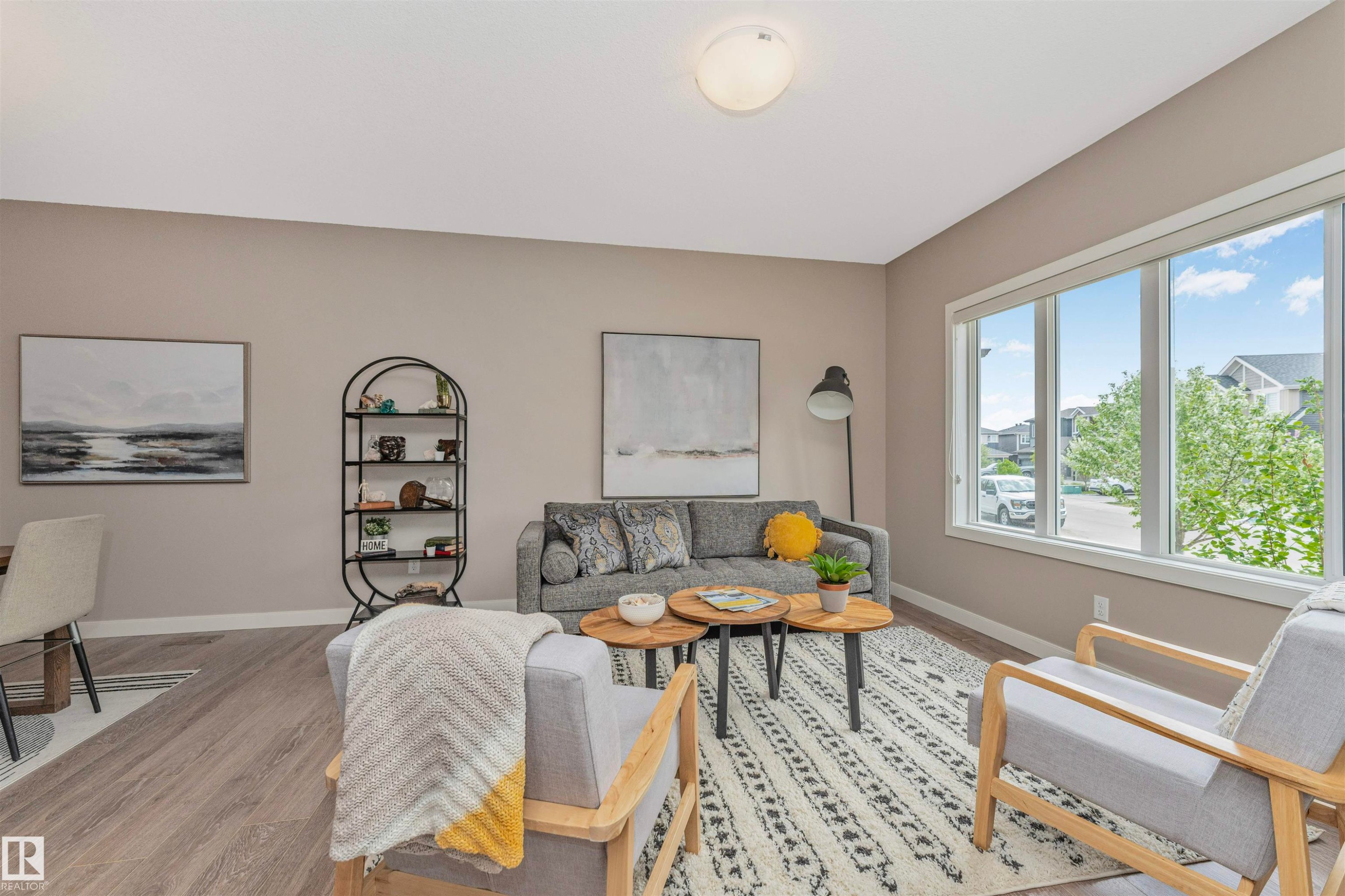 Spacious living area featuring wood-finish flooring, a large multi-pane window, and neutral wall tones - 22124 85 Avenue Nw, Edmonton, AB - Indoor Photo Showing Living Room
