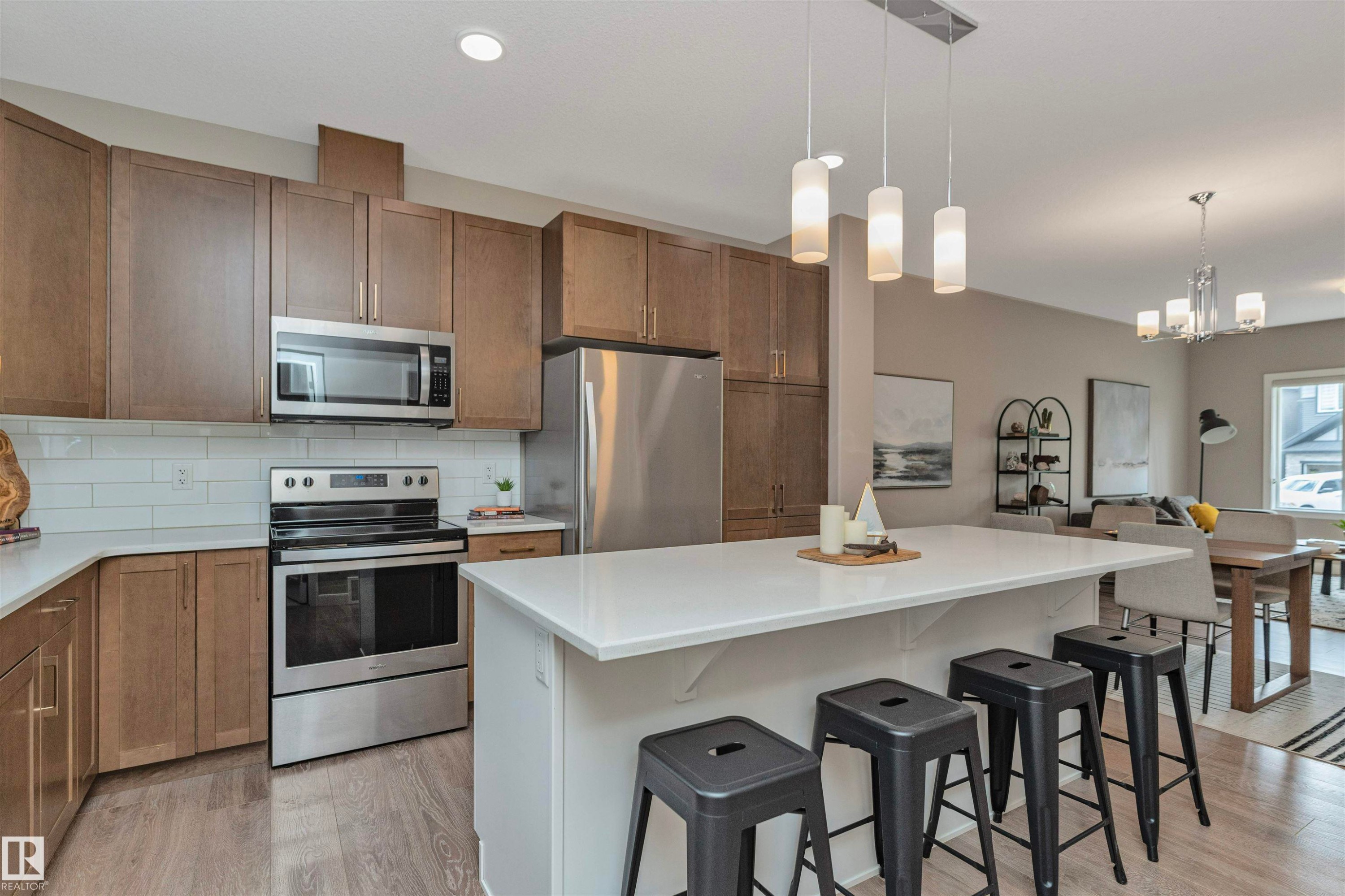 Modern kitchen featuring wood-finish cabinetry, stainless steel appliances, a white subway tile backsplash, and a central island with a solid surface countertop - 22124 85 Avenue Nw, Edmonton, AB - Indoor Photo Showing Kitchen With Stainless Steel Kitchen With Upgraded Kitchen