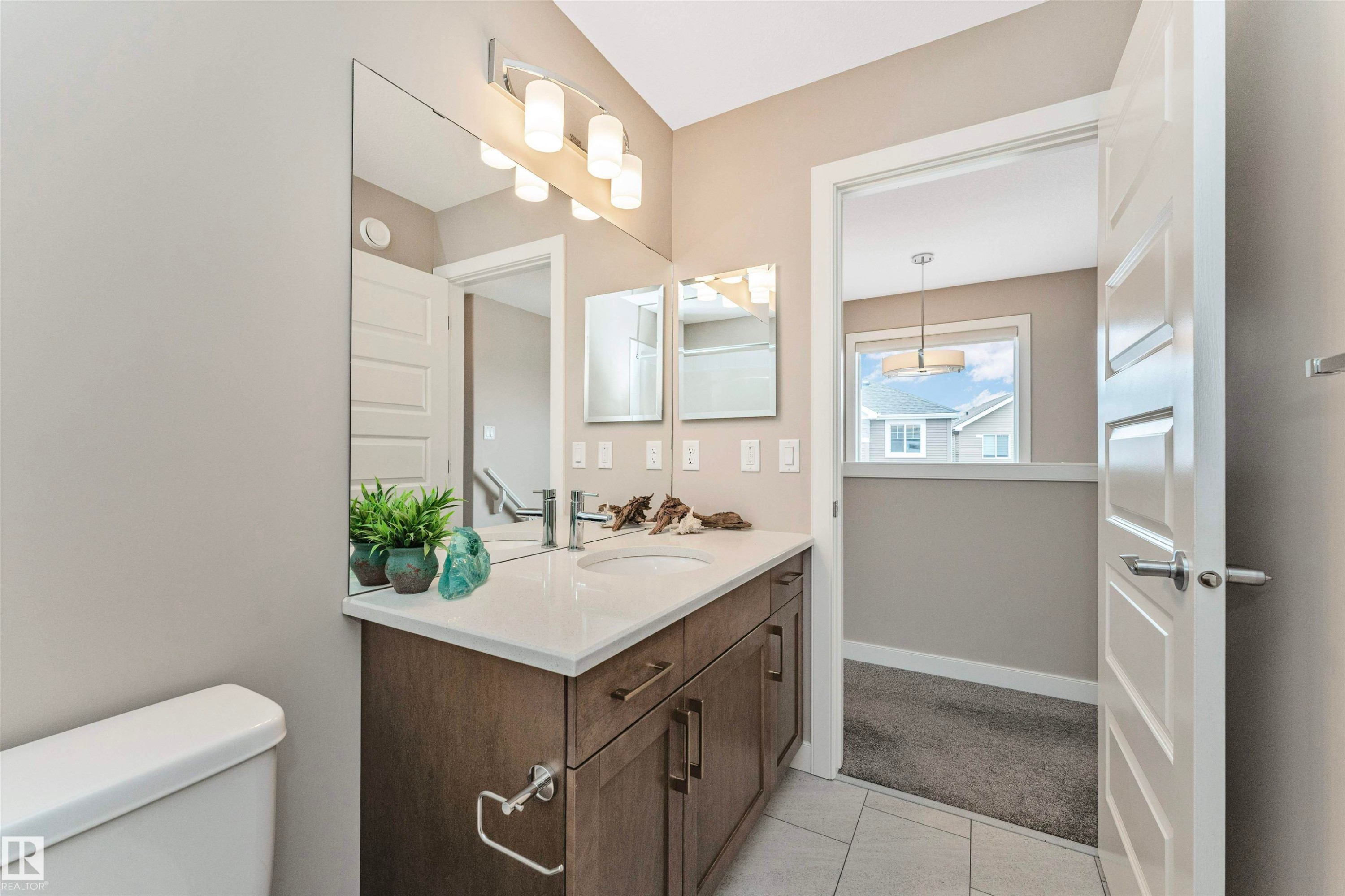 Bathroom vanity featuring a single integrated sink, white countertop, and dark wood-finish cabinetry - 22124 85 Avenue Nw, Edmonton, AB - Indoor Photo Showing Bathroom