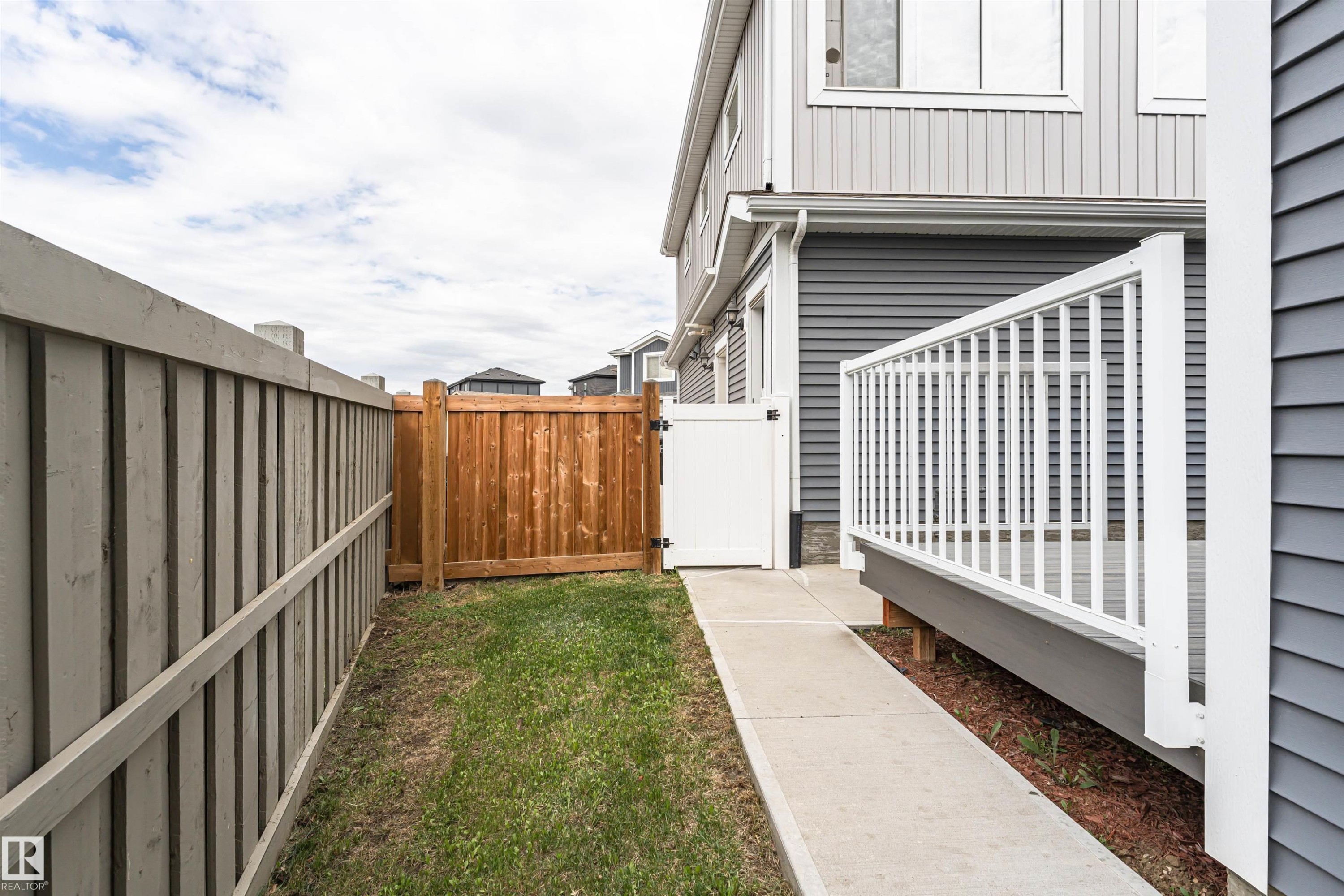 Side yard featuring a concrete pathway and grass - 22124 85 Avenue Nw, Edmonton, AB - Outdoor With Exterior