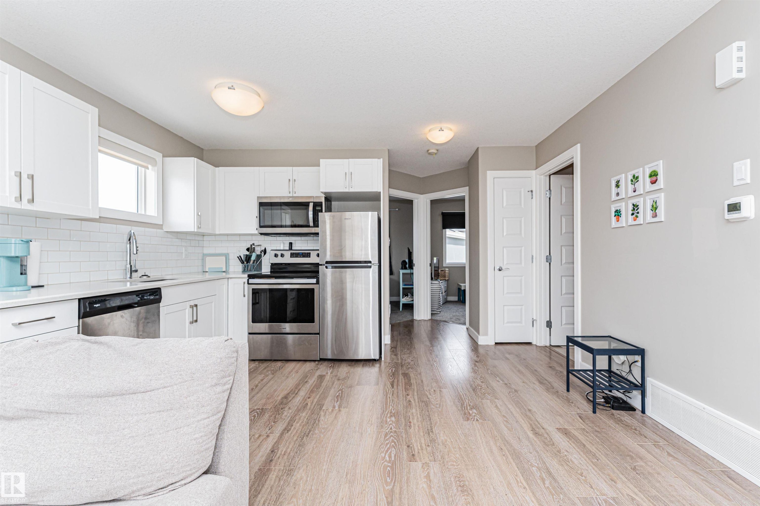 Modern kitchen featuring white cabinetry, subway tile backsplash, stainless steel appliances, and white countertops - 22124 85 Avenue Nw, Edmonton, AB - Indoor Photo Showing Kitchen With Stainless Steel Kitchen