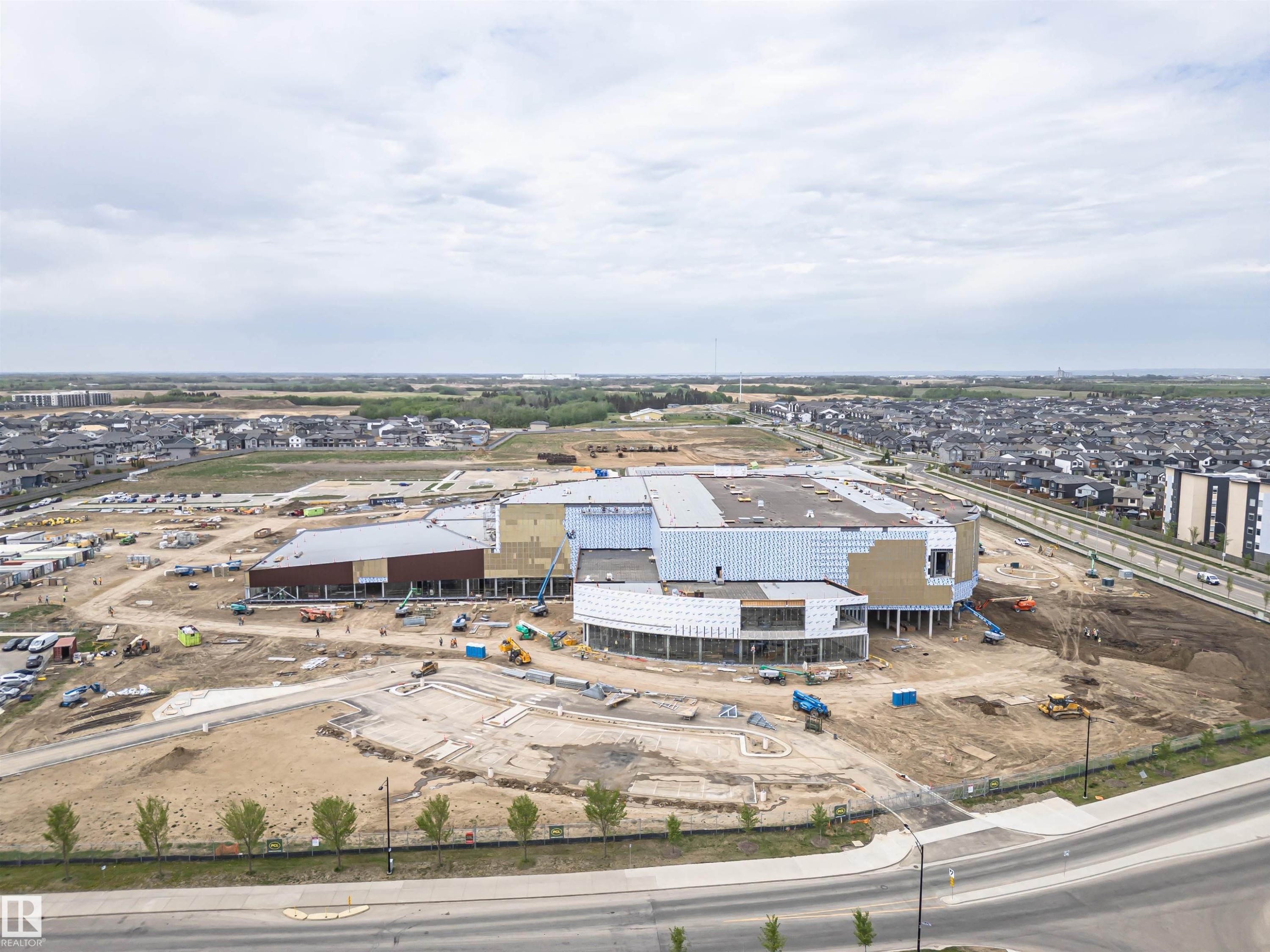 Large-scale commercial development featuring multiple interconnected structures, extensive groundwork for future expansion, and a diverse range of building materials including brown facade panels and white exterior sheathing - 22124 85 Avenue Nw, Edmonton, AB - Outdoor With View