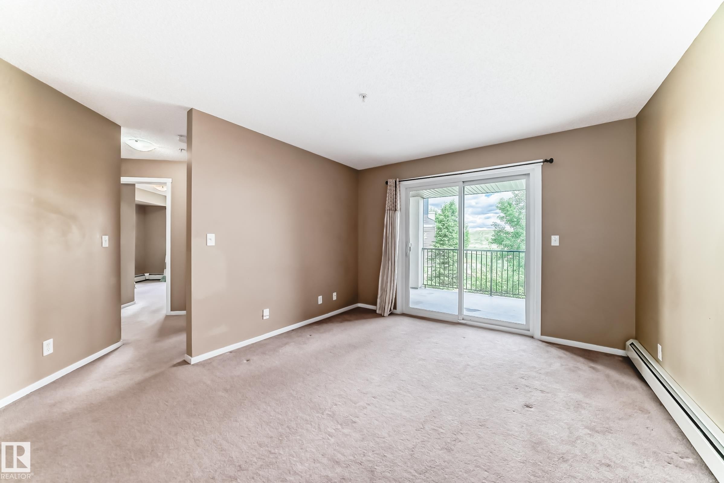 Spacious interior with neutral-toned walls, plush carpeting, and white trim - 215 1510 Watt Drive, Edmonton, AB