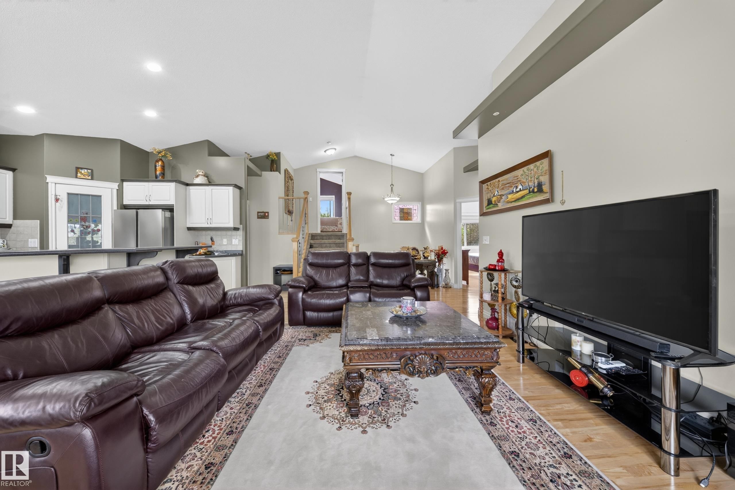 Open-concept living area featuring vaulted ceilings and hardwood-style flooring - 4113 59 Street, Beaumont, AB