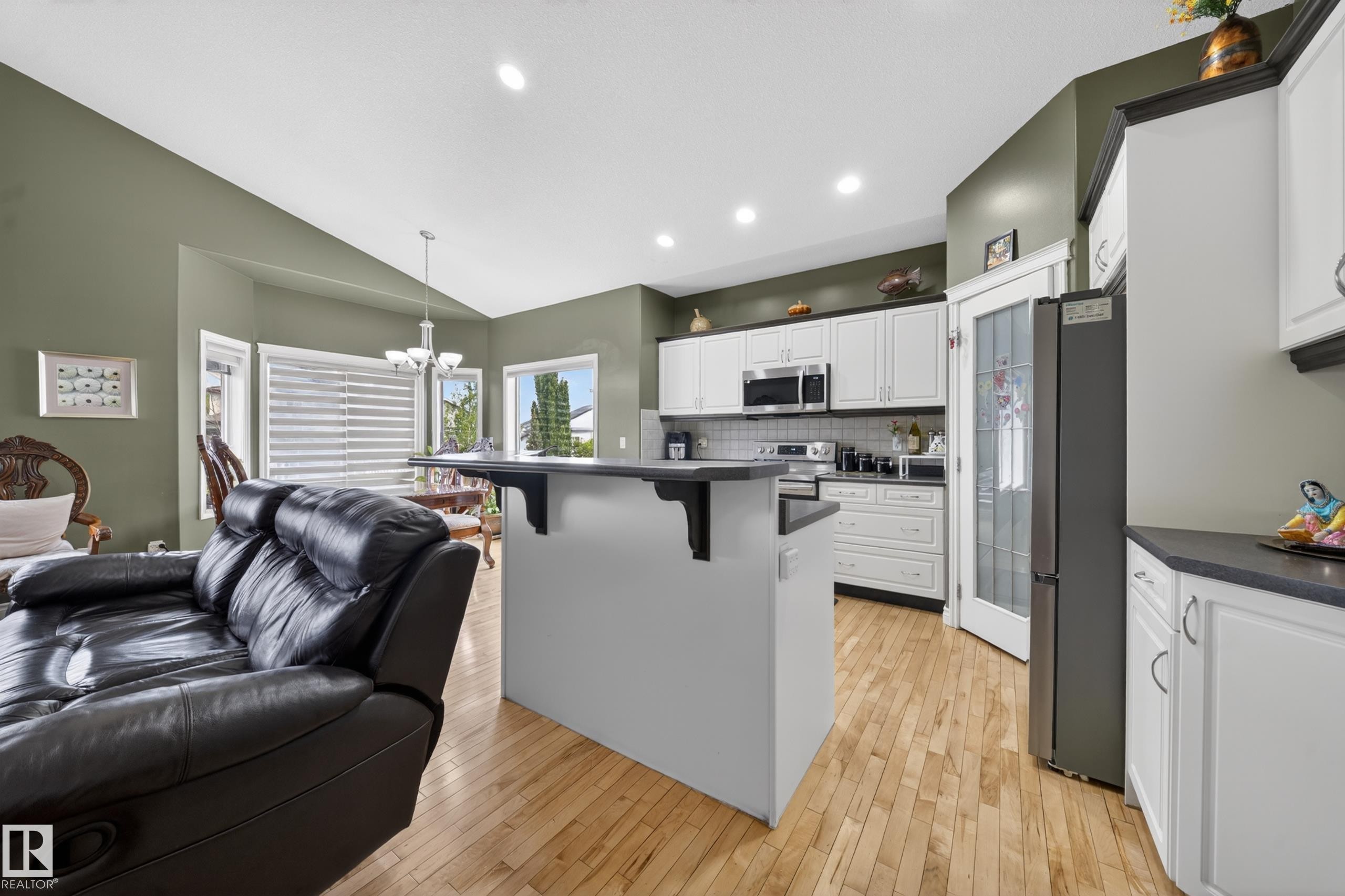 Kitchen featuring white cabinetry, dark countertops, and stainless steel appliances - 4113 59 Street, Beaumont, AB