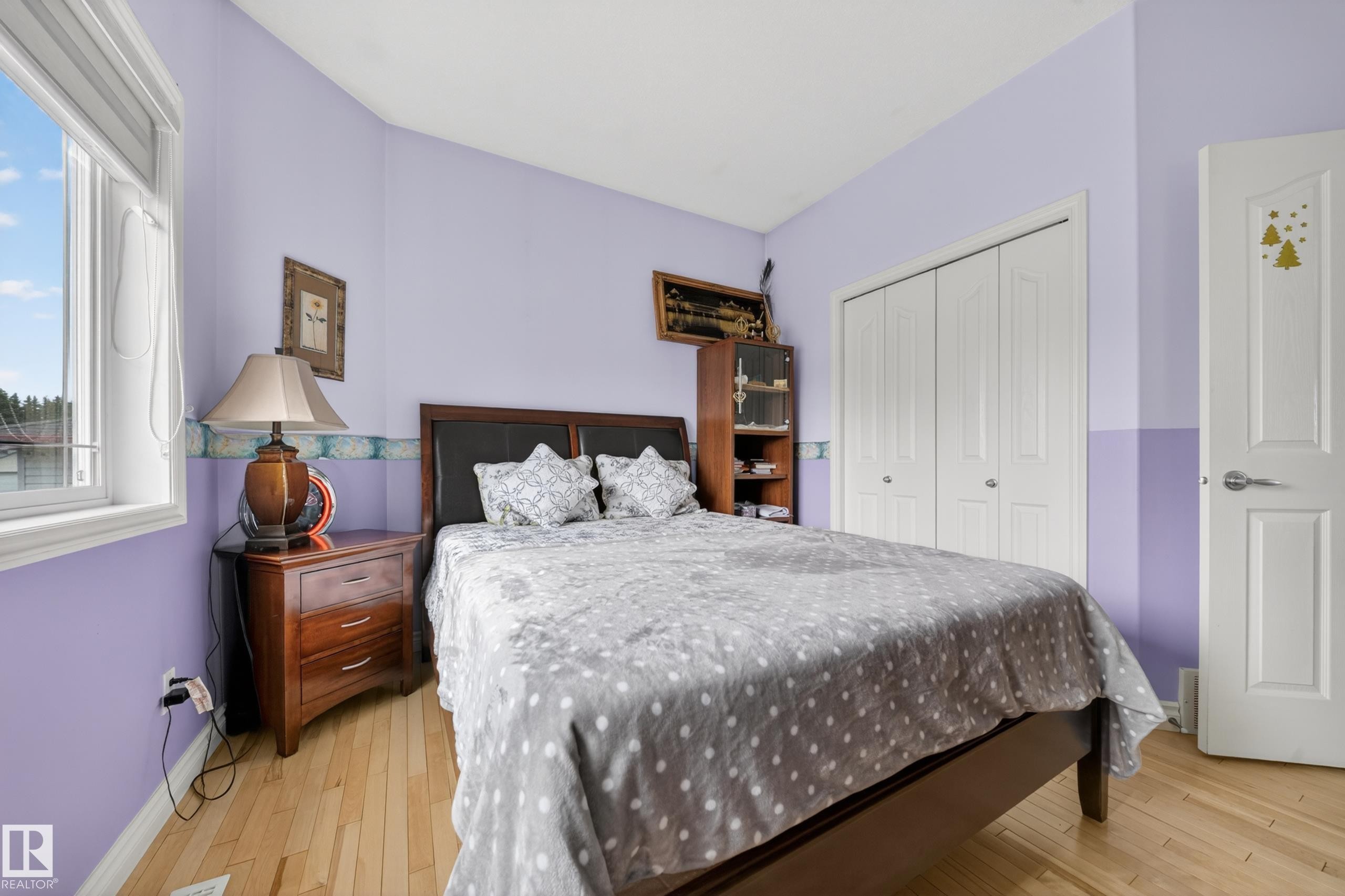 Bedroom with light wood-finish flooring and a double-door closet - 4113 59 Street, Beaumont, AB