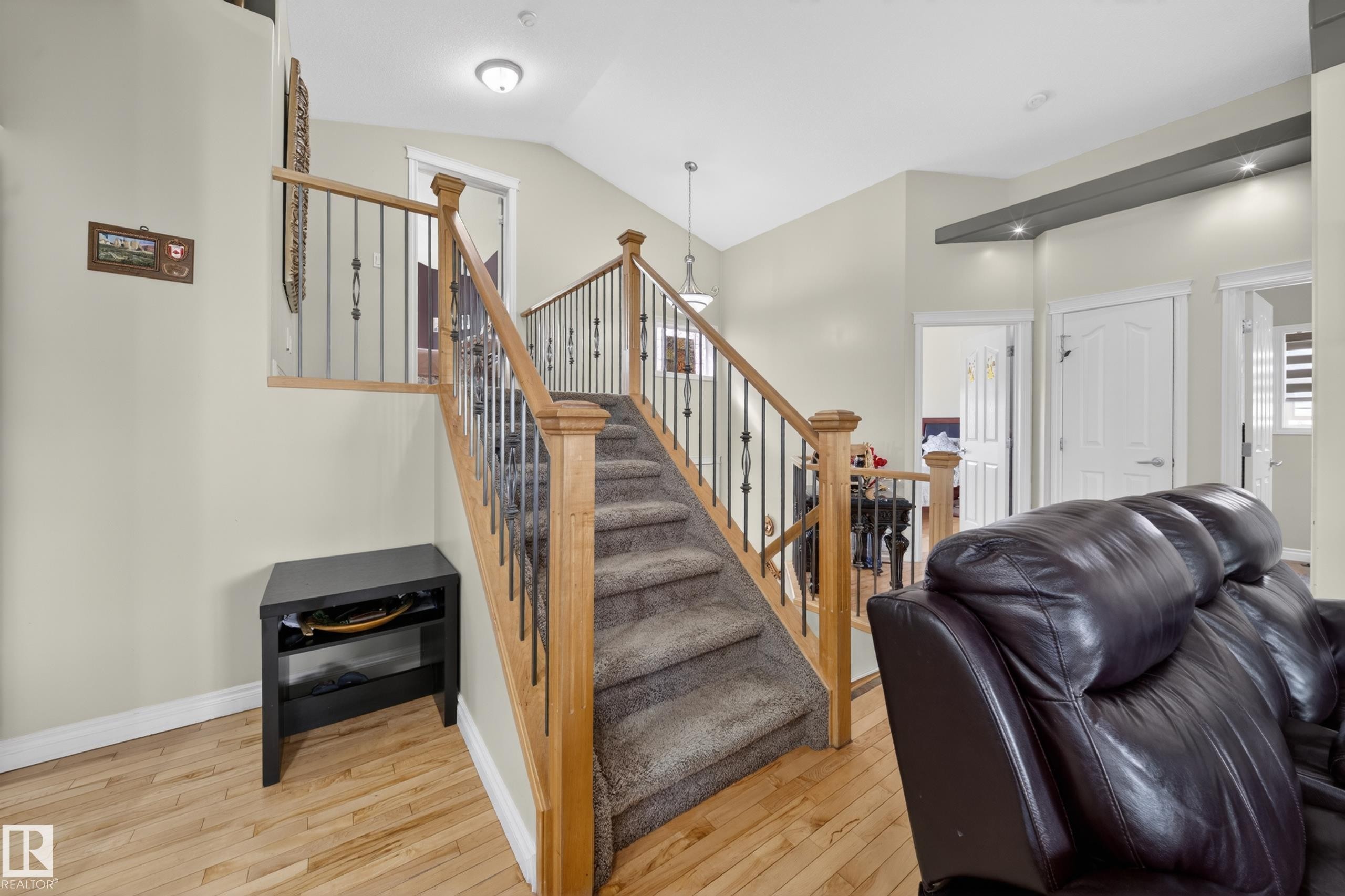 Carpeted stairway featuring wooden newel posts and metal spindles - 4113 59 Street, Beaumont, AB