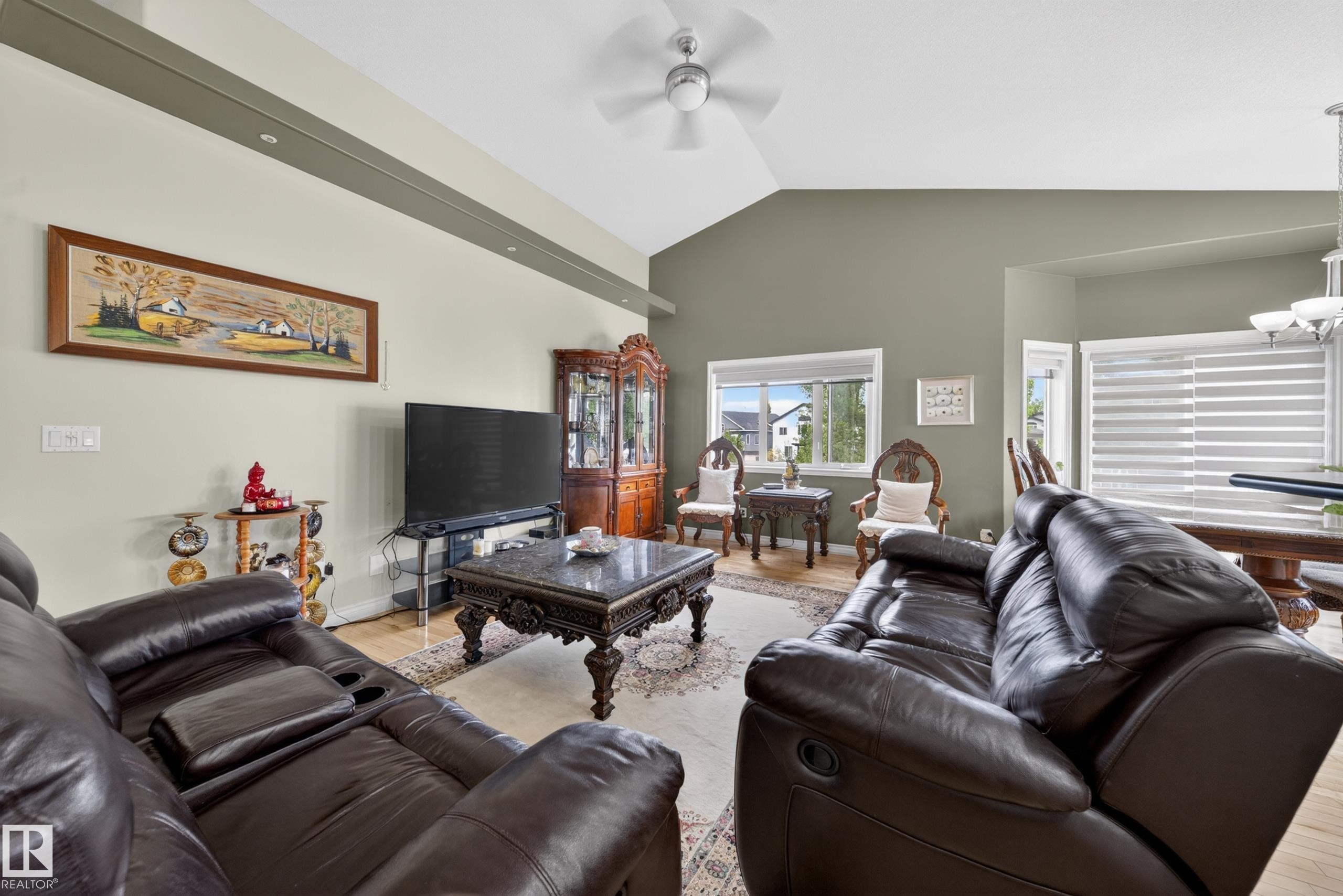 Vaulted ceiling living area featuring recessed lighting, light wood-finish flooring, and multiple windows with blinds - 4113 59 Street, Beaumont, AB