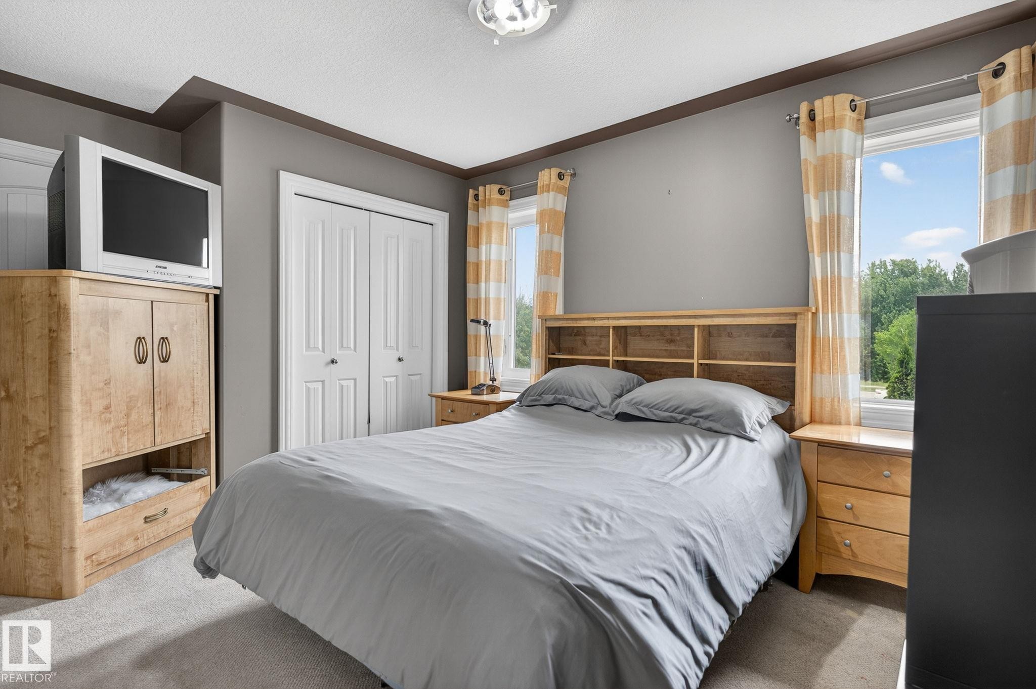 Kitchen featuring wood cabinetry, granite countertops, a black tile backsplash, and stainless steel appliances - 1508 Palmer Close, Edmonton, AB