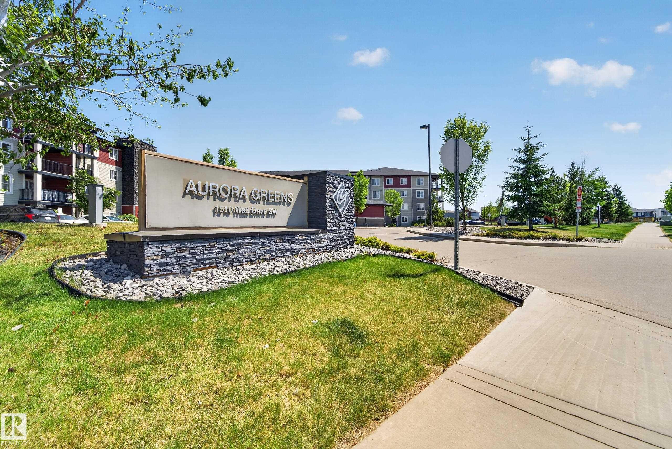 Stone-clad monument sign with "Aurora Greens" text and address - 225 1510 Watt Drive, Edmonton, AB - Outdoor With View