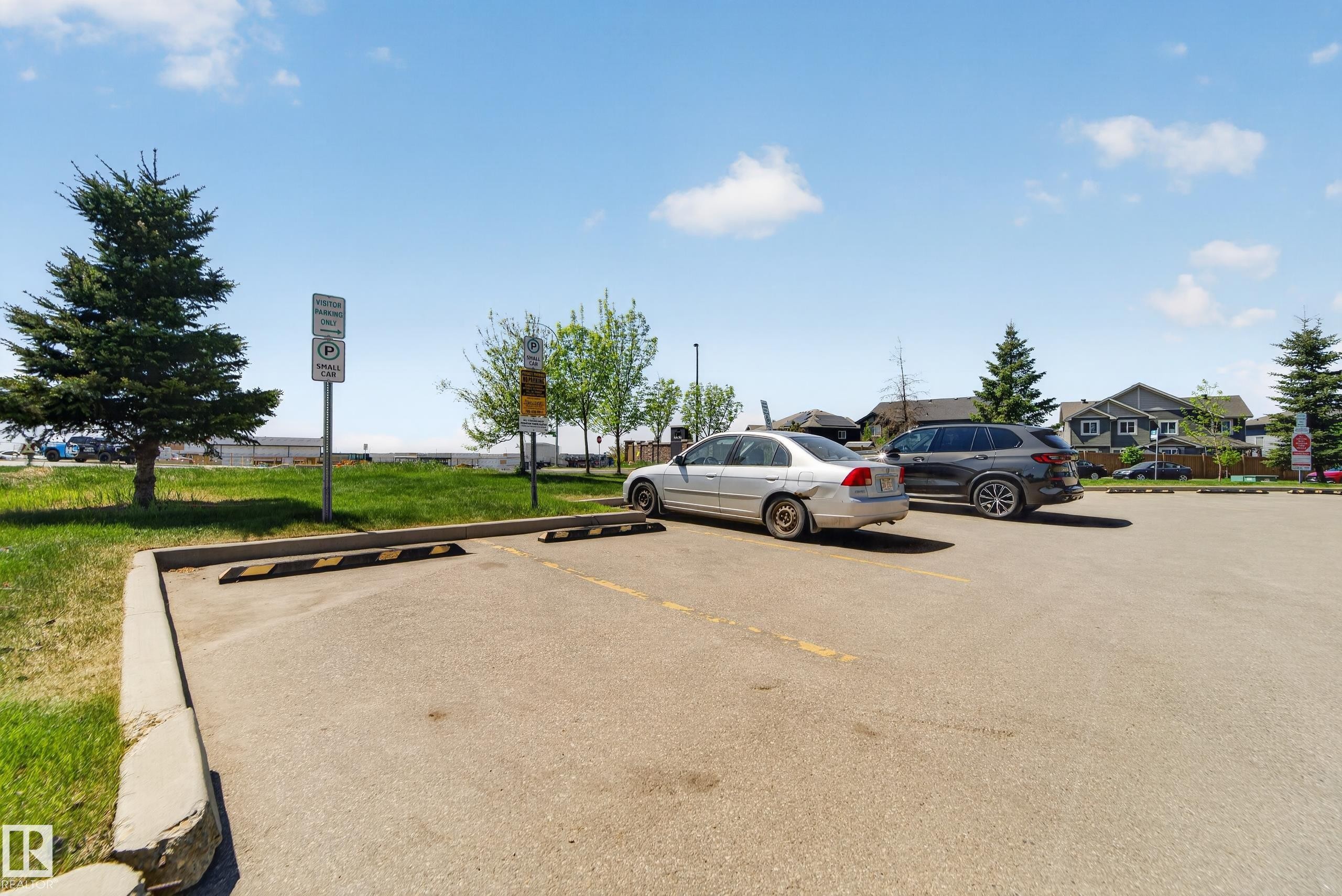 Paved parking area with marked spaces and concrete curbing - 225 1510 Watt Drive, Edmonton, AB - Outdoor
