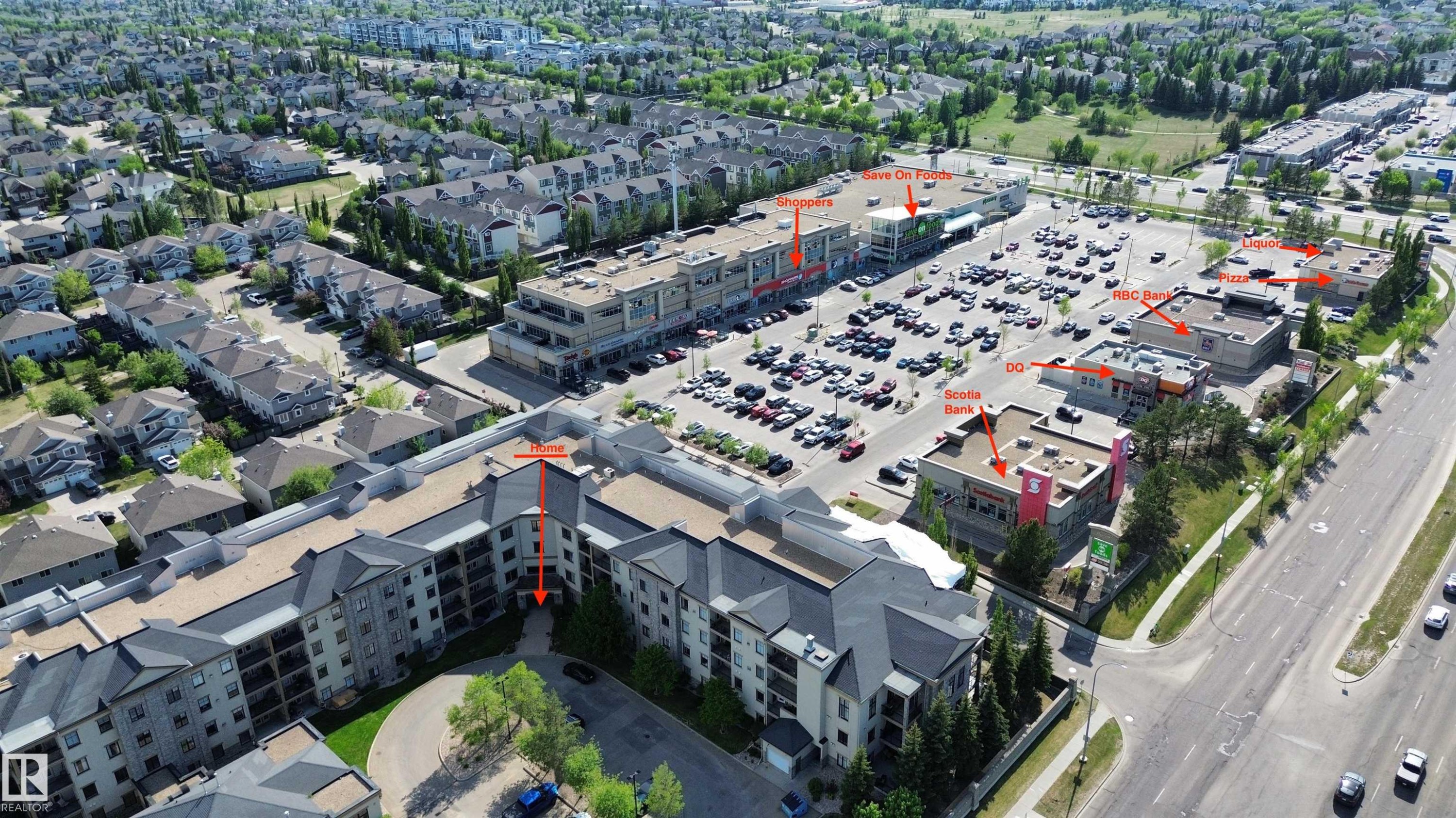 Aerial perspective showcasing the multi-story residential building and surrounding commercial properties - 117 160 Magrath Road, Edmonton, AB - Outdoor With View