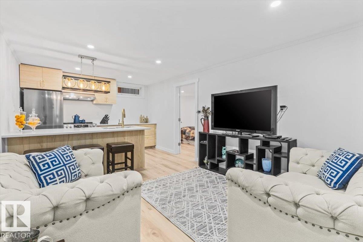 Open-concept living area featuring light wood-finish flooring and recessed lighting - 6720 29 Avenue, Edmonton, AB
