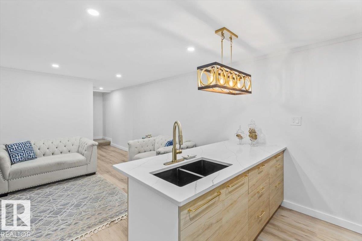 Kitchen island with a dual black sink and a gold-finish faucet - 6720 29 Avenue, Edmonton, AB