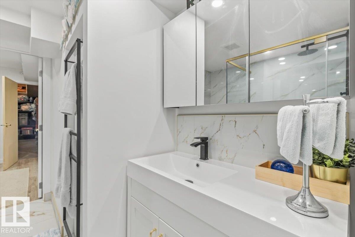 Contemporary vanity featuring a white rectangular sink with a matte black faucet, integrated storage, and a mirrored medicine cabinet - 6720 29 Avenue, Edmonton, AB