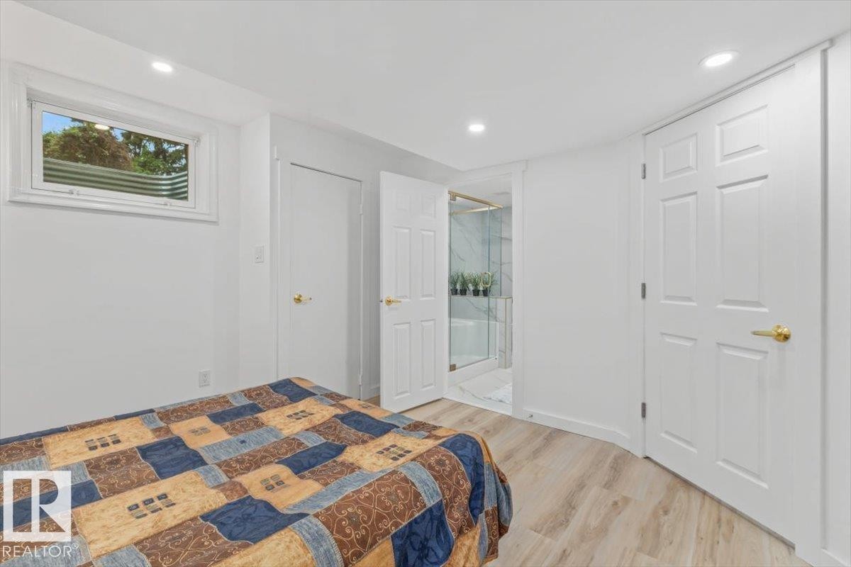 Bedroom featuring light wood-finish flooring, recessed lighting, and a window with a window well - 6720 29 Avenue, Edmonton, AB