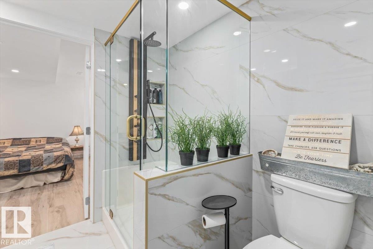 Glass-enclosed shower with gold-tone accents, a rain shower head, and an integrated shelf - 6720 29 Avenue, Edmonton, AB
