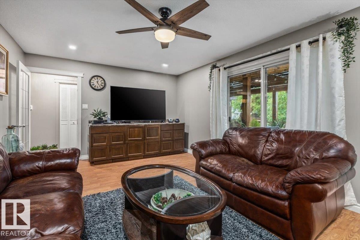 Spacious living area featuring wood-finish flooring, recessed lighting, and a ceiling fan with integrated light - 6720 29 Avenue, Edmonton, AB