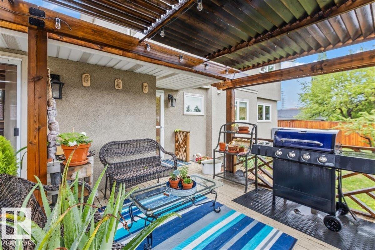 Covered outdoor deck featuring natural wood beams and slatted ceiling - 6720 29 Avenue, Edmonton, AB