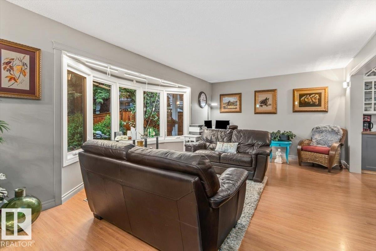 Living area featuring a wide bay window and wood-finish flooring - 6720 29 Avenue, Edmonton, AB