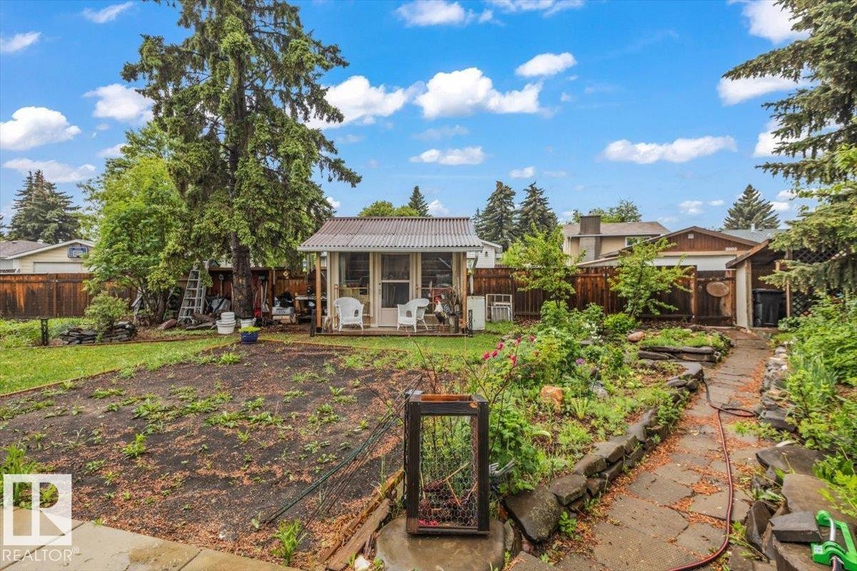 Backyard featuring a shed with a front porch and a corrugated metal roof - 6720 29 Avenue, Edmonton, AB