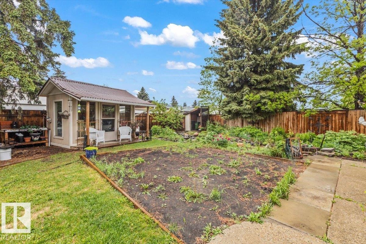 Backyard space featuring a detached outbuilding with a porch and metal roof - 6720 29 Avenue, Edmonton, AB