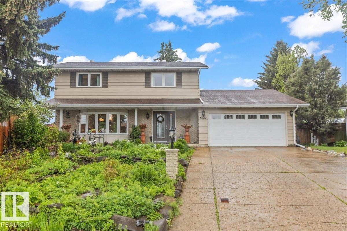 Split-level residence featuring a two-car garage with paneling and upper transom windows - 6720 29 Avenue, Edmonton, AB