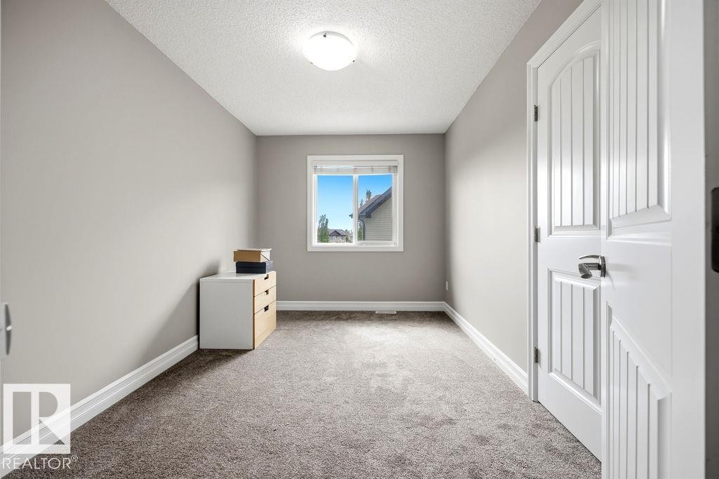 Light-filled room featuring neutral wall paint, white baseboards, and textured carpeting - 13703 166 Avenue Nw, Edmonton, AB - Indoor